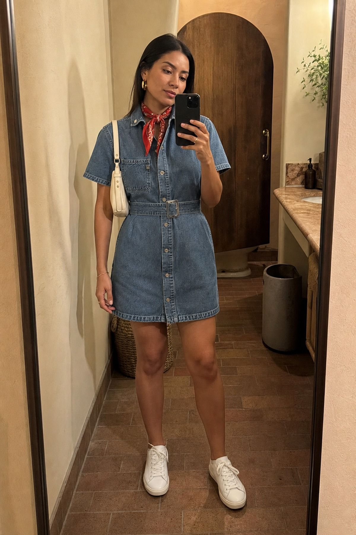 Woman wearing a denim dress with white sneakers