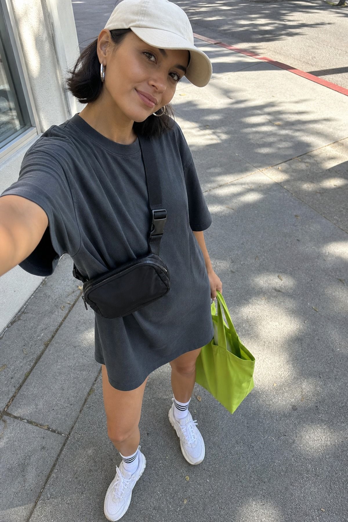Woman wearing a t-shirt dress with a baseball cap