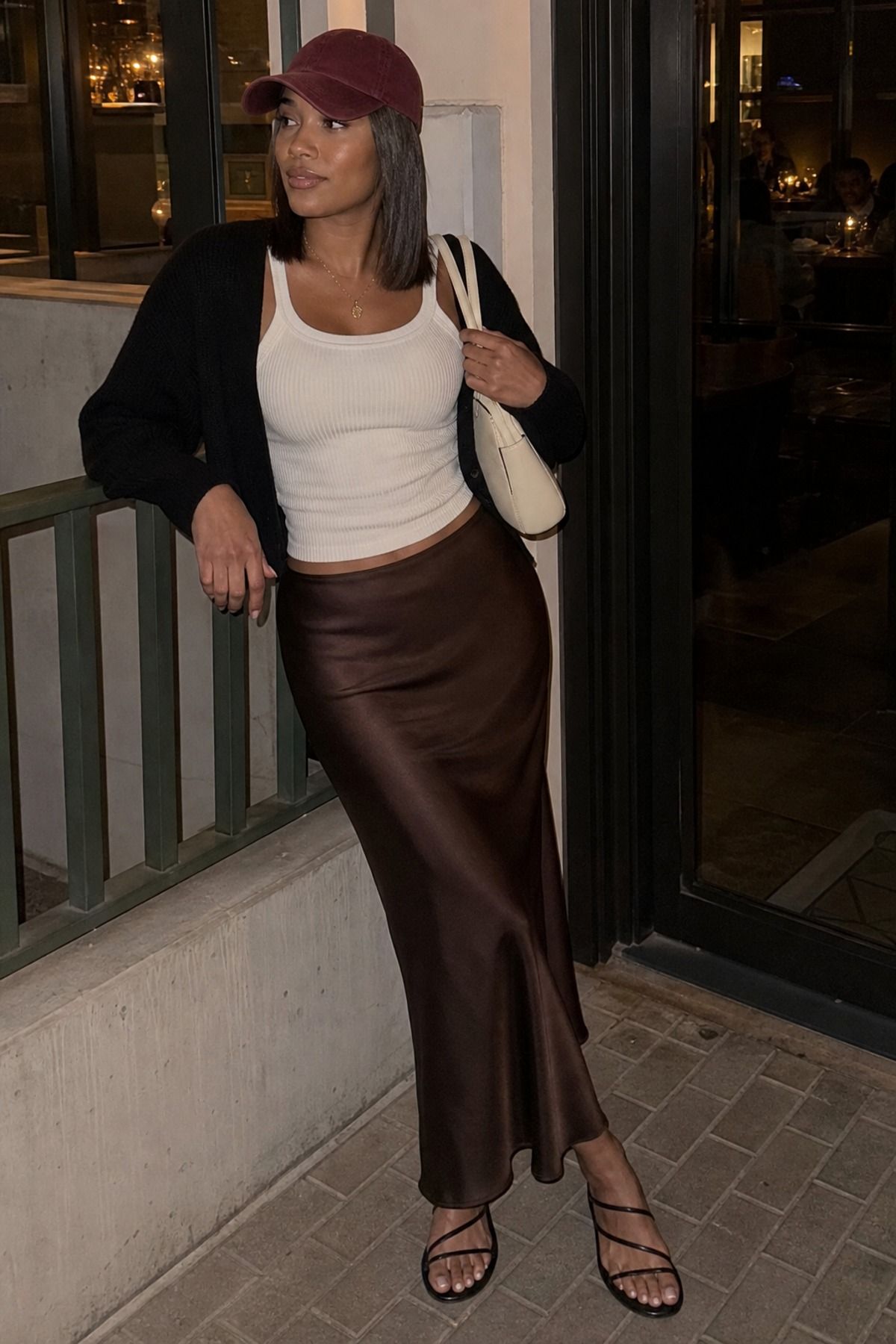 Woman wearing a slip skirt outfit with a baseball cap