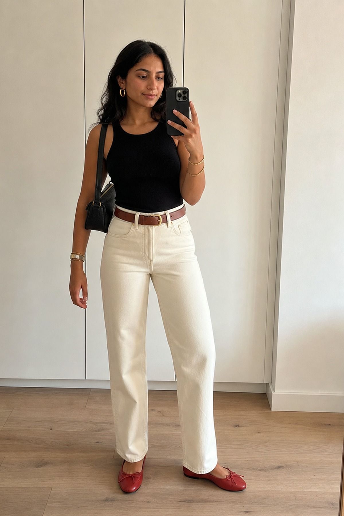 Woman wearing a black tank with ecru denim, an effortless chic outfit