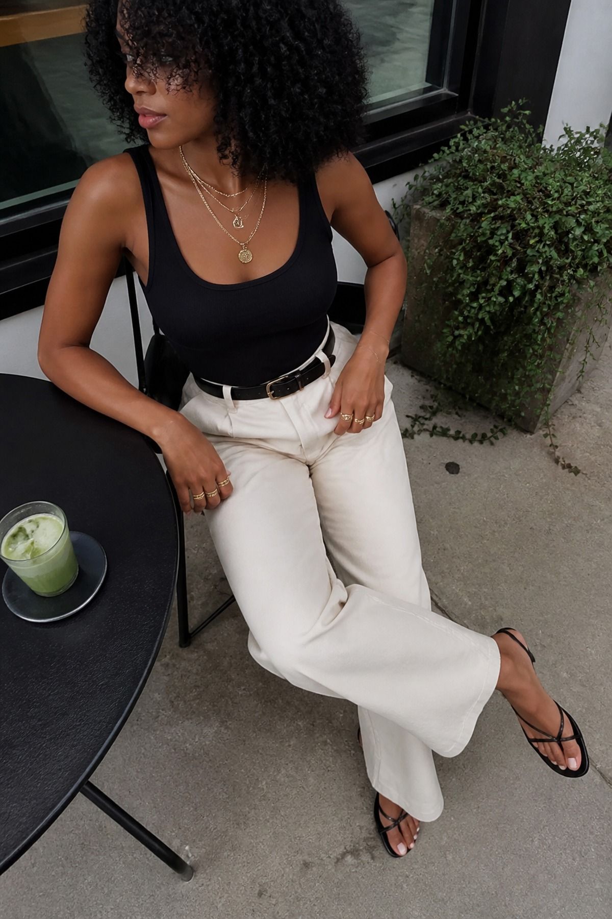 Woman wearing a tank and trousers with gold jewelry