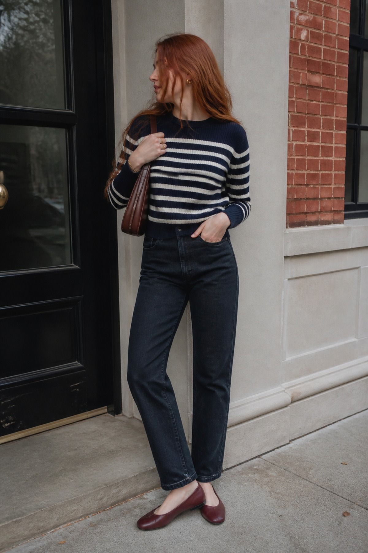 Woman wearing a striped sweater outfit with gold jewelry