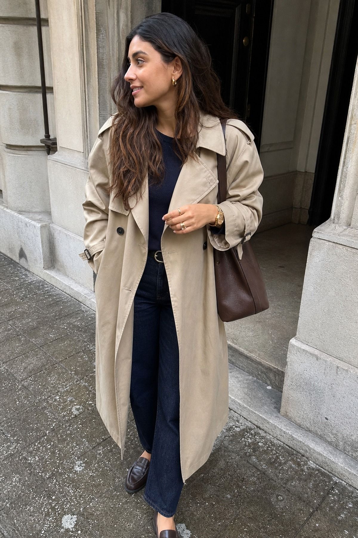 Woman wearing a trench coat outfit with gold jewelry