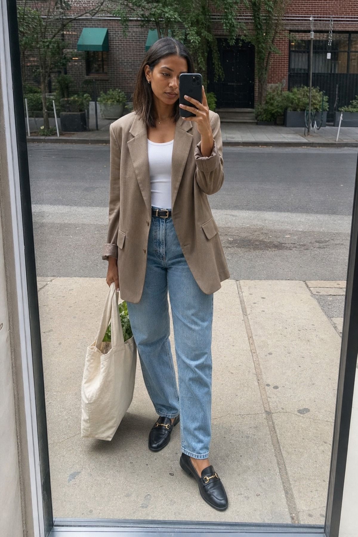Woman wearing a taupe blazer with relaxed denim, a minimalist outfit