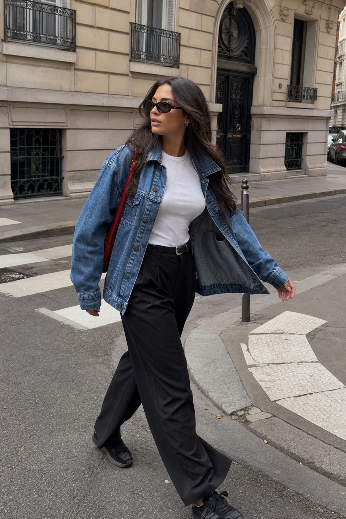 Woman wearing a denim jacket with black trousers, a model off duty outfit