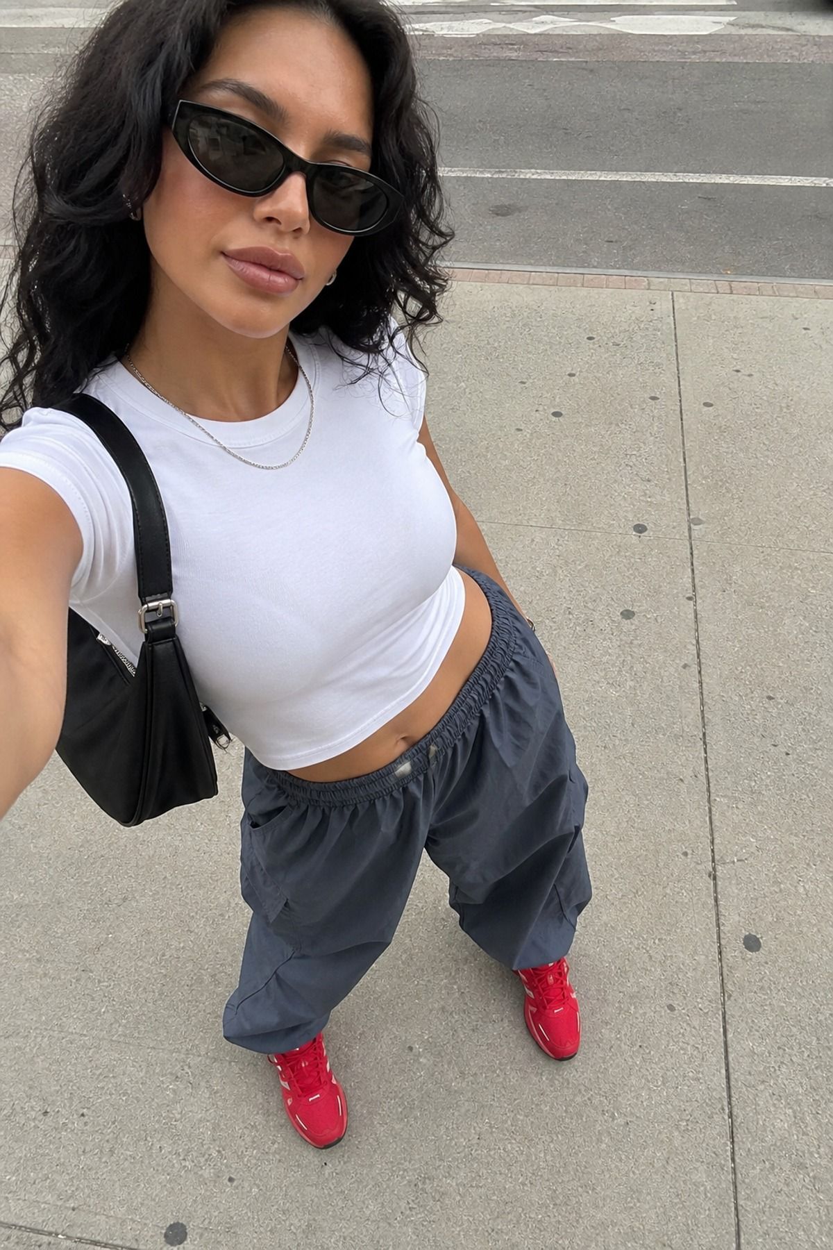 Woman wearing a cropped tee with parachute pants, a model off duty outfit