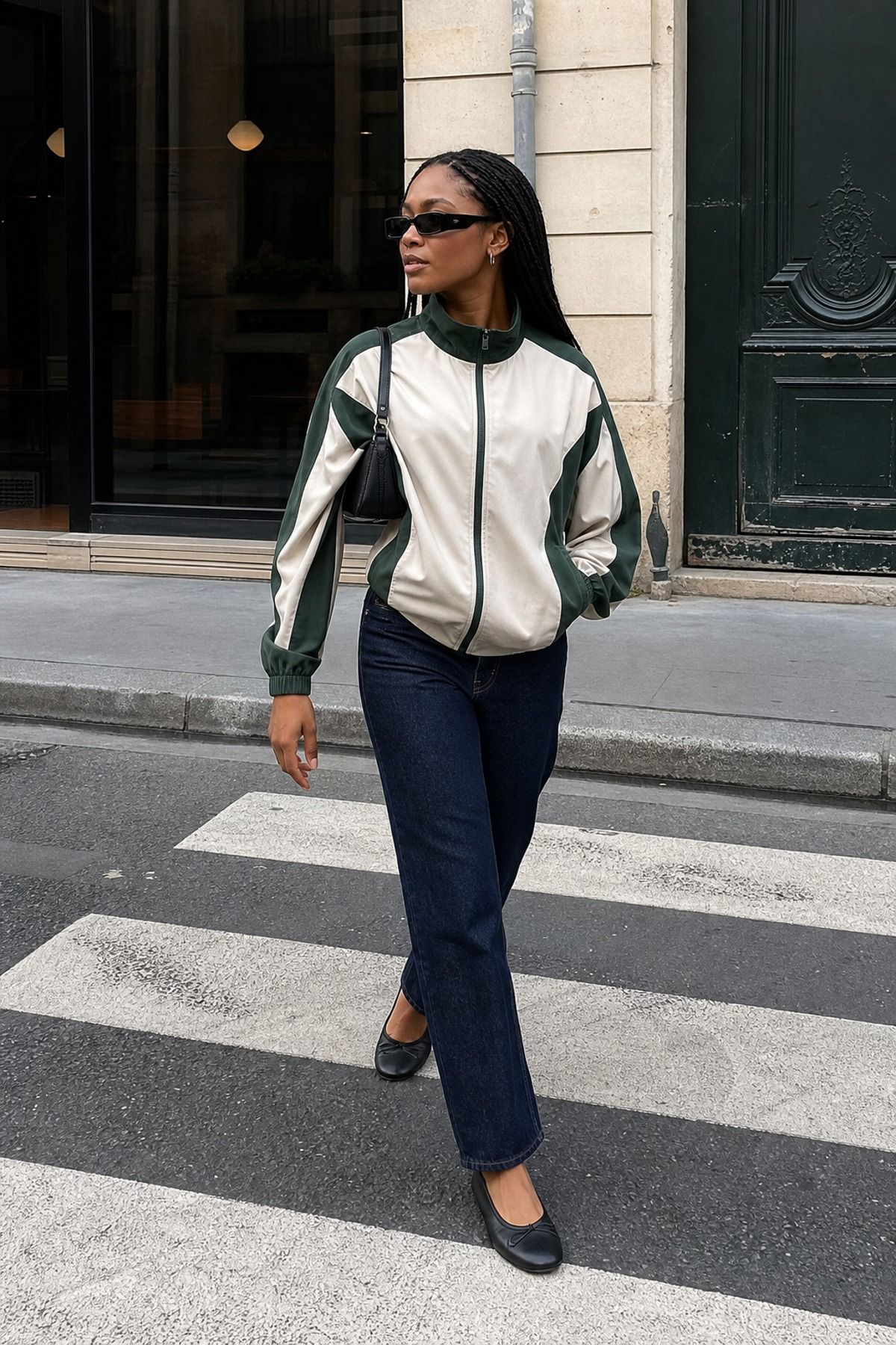 Woman wearing a track jacket with dark denim, a model off duty outfit