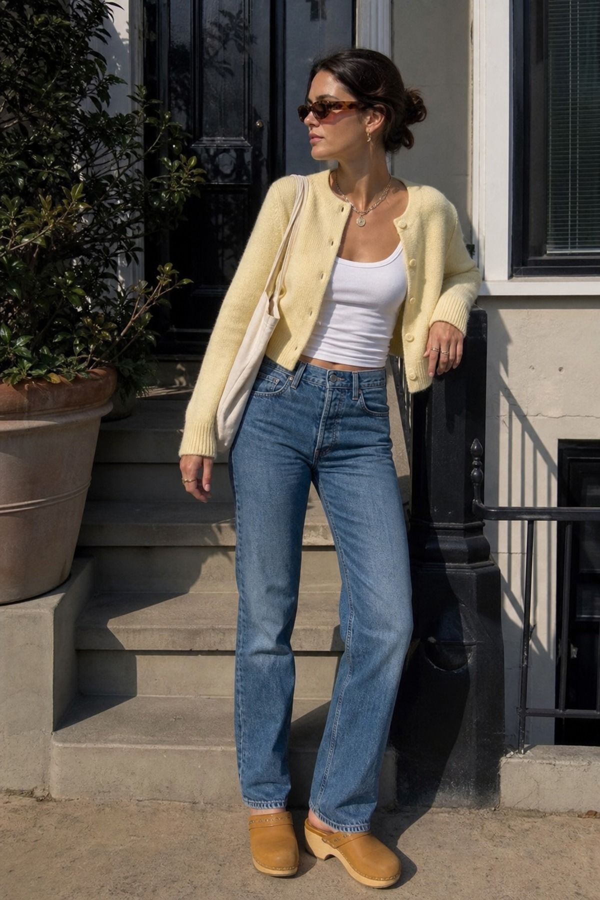 Woman wearing a cardigan and jeans with sunglasses