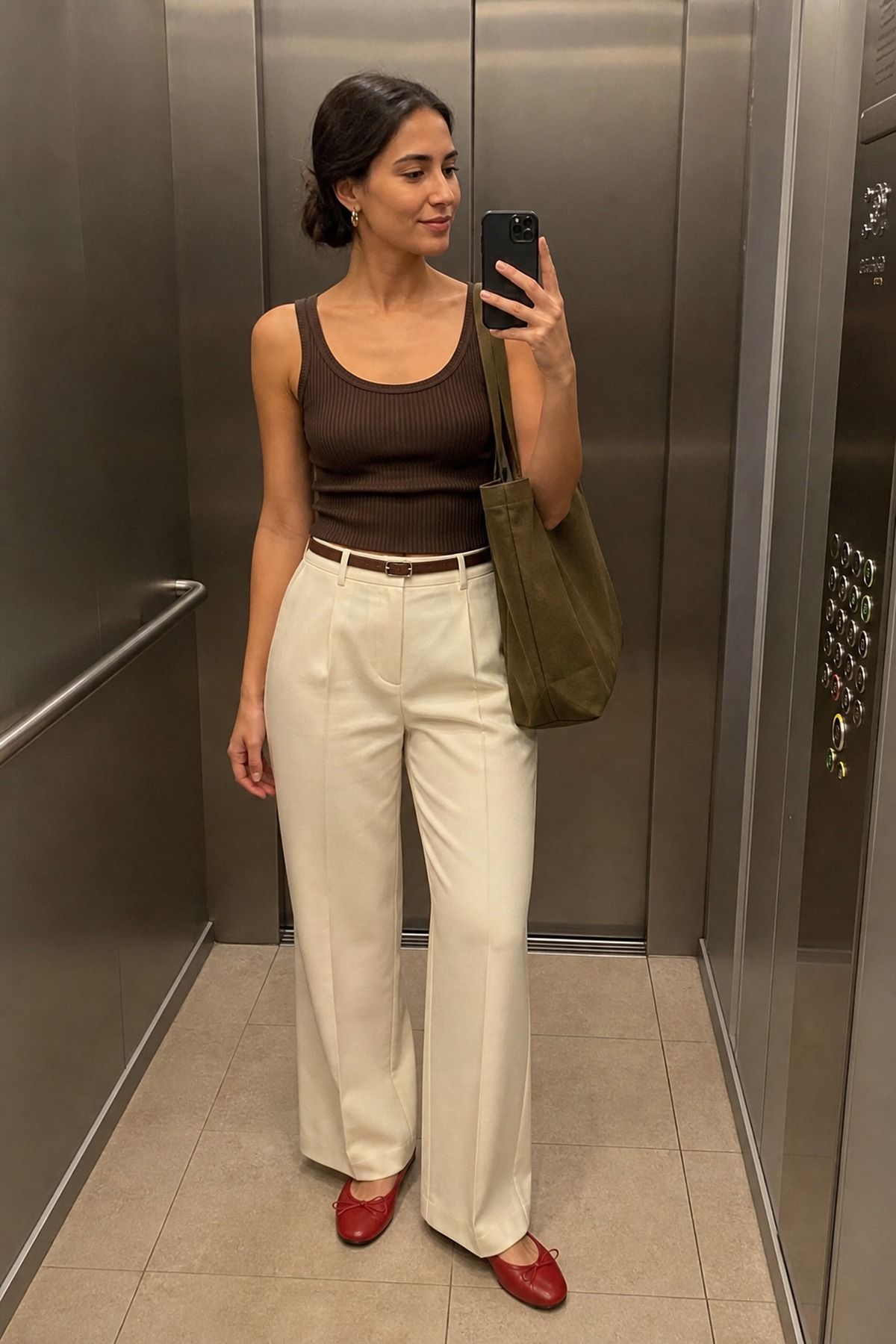 Woman wearing a tank top and trousers with a tote bag