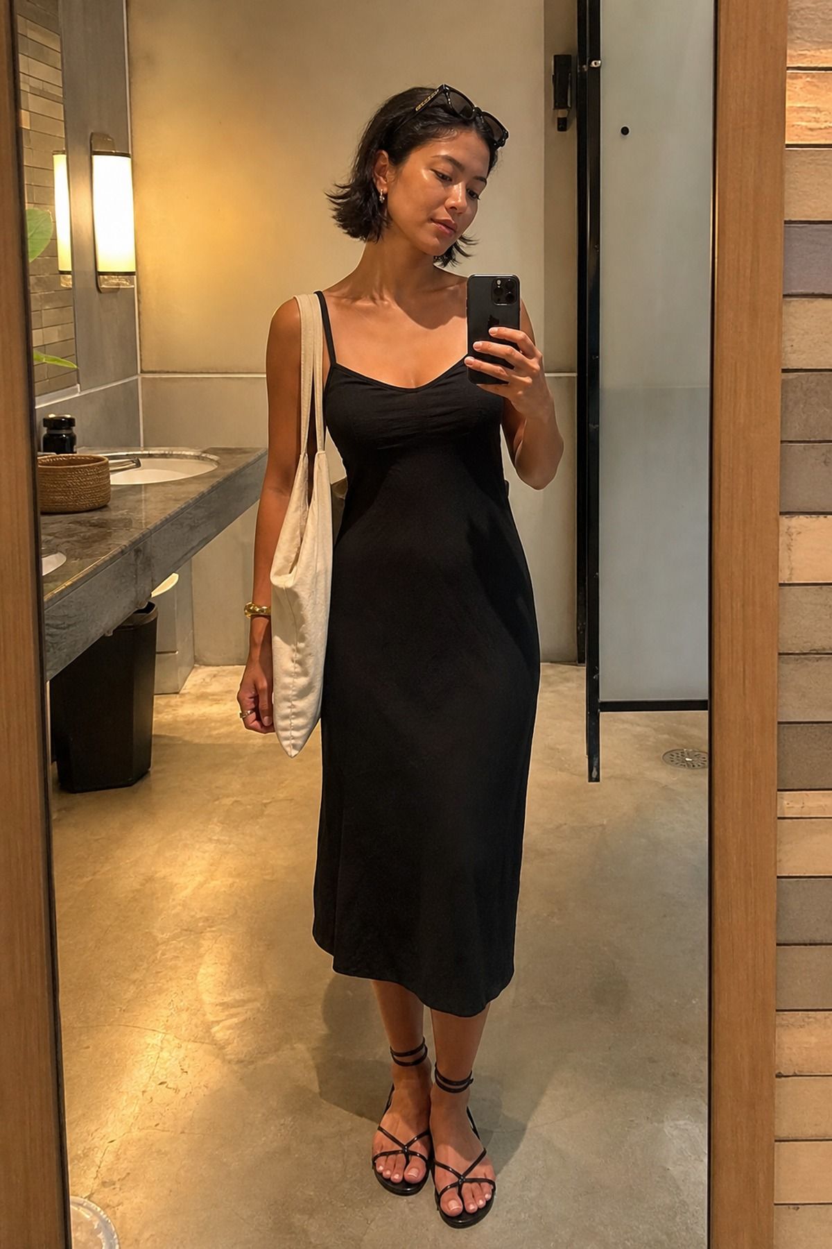Woman wearing a black dress and carrying a tote bag