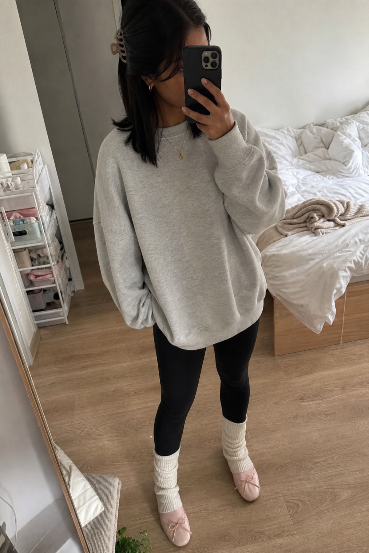 Woman wearing leg warmers with leggings and an oversized sweatshirt, a balletcore casual outfit
