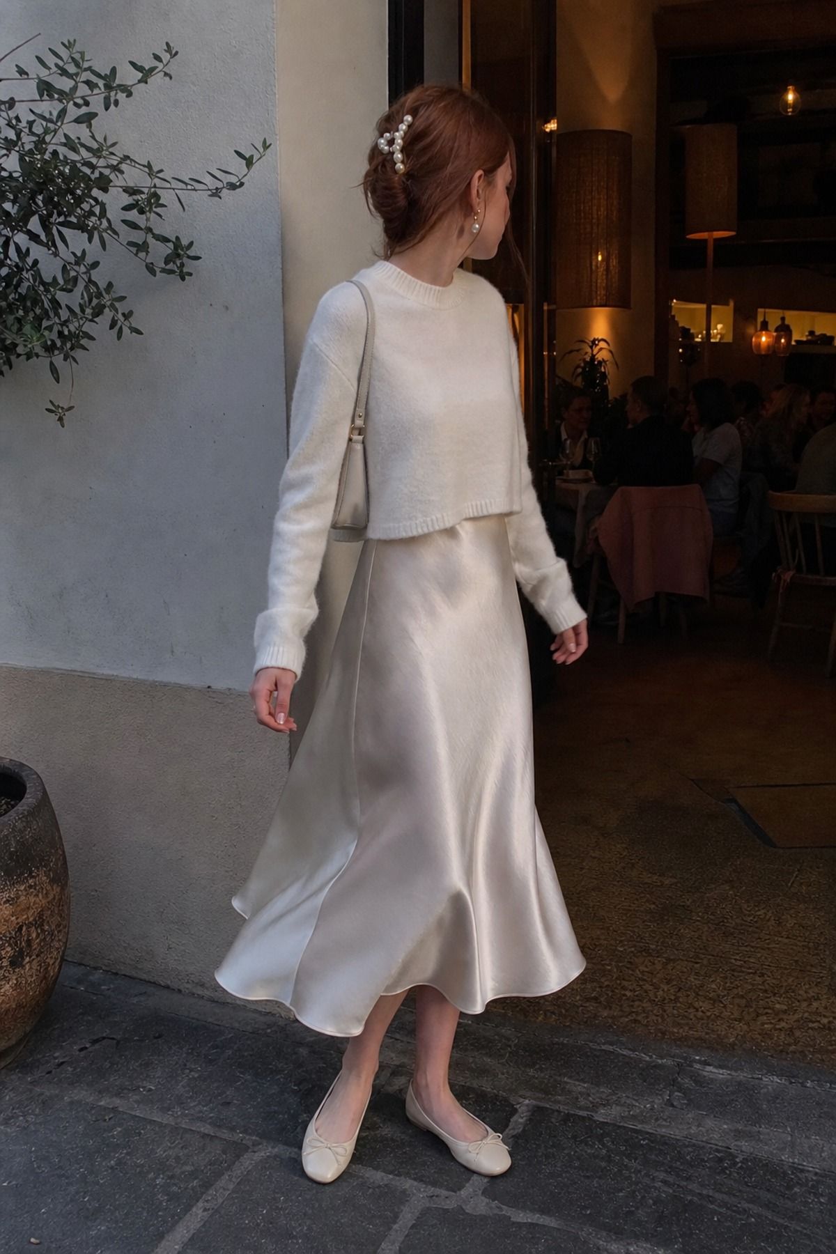 Woman wearing a satin slip dress with a soft crewneck sweater, a balletcore casual outfit