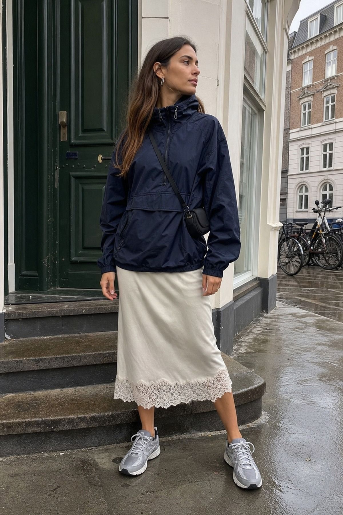 Woman wearing a sporty anorak with a lace trim slip skirt, a copenhagen style outfit