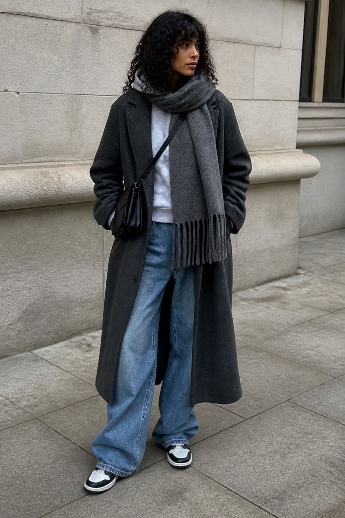 Woman wearing an oversized coat with a hoodie and wide jeans, a downtown girl outfit