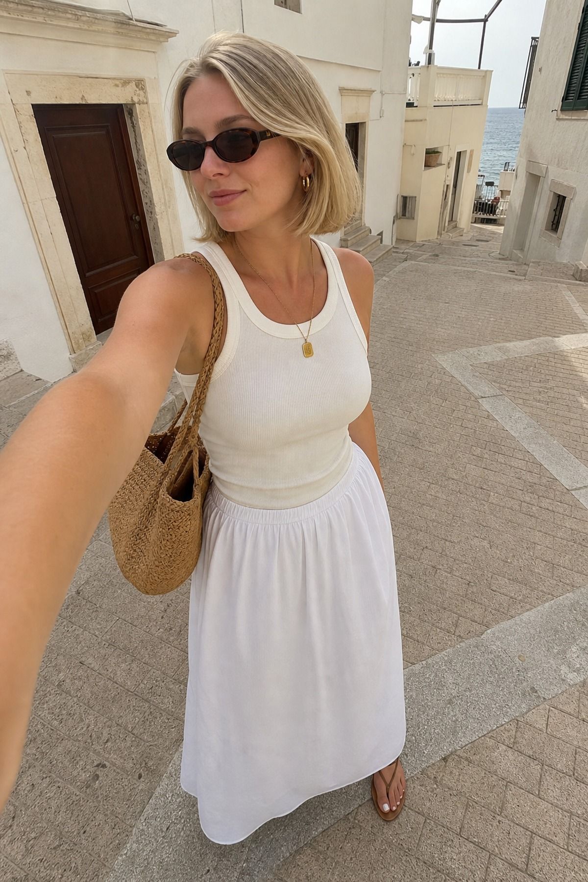 Woman wearing a white maxi skirt with a ribbed tank, a European summer outfit