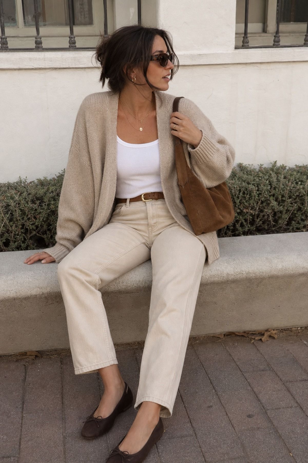 Woman wearing an oatmeal cardigan with cream denim, a light academia outfit