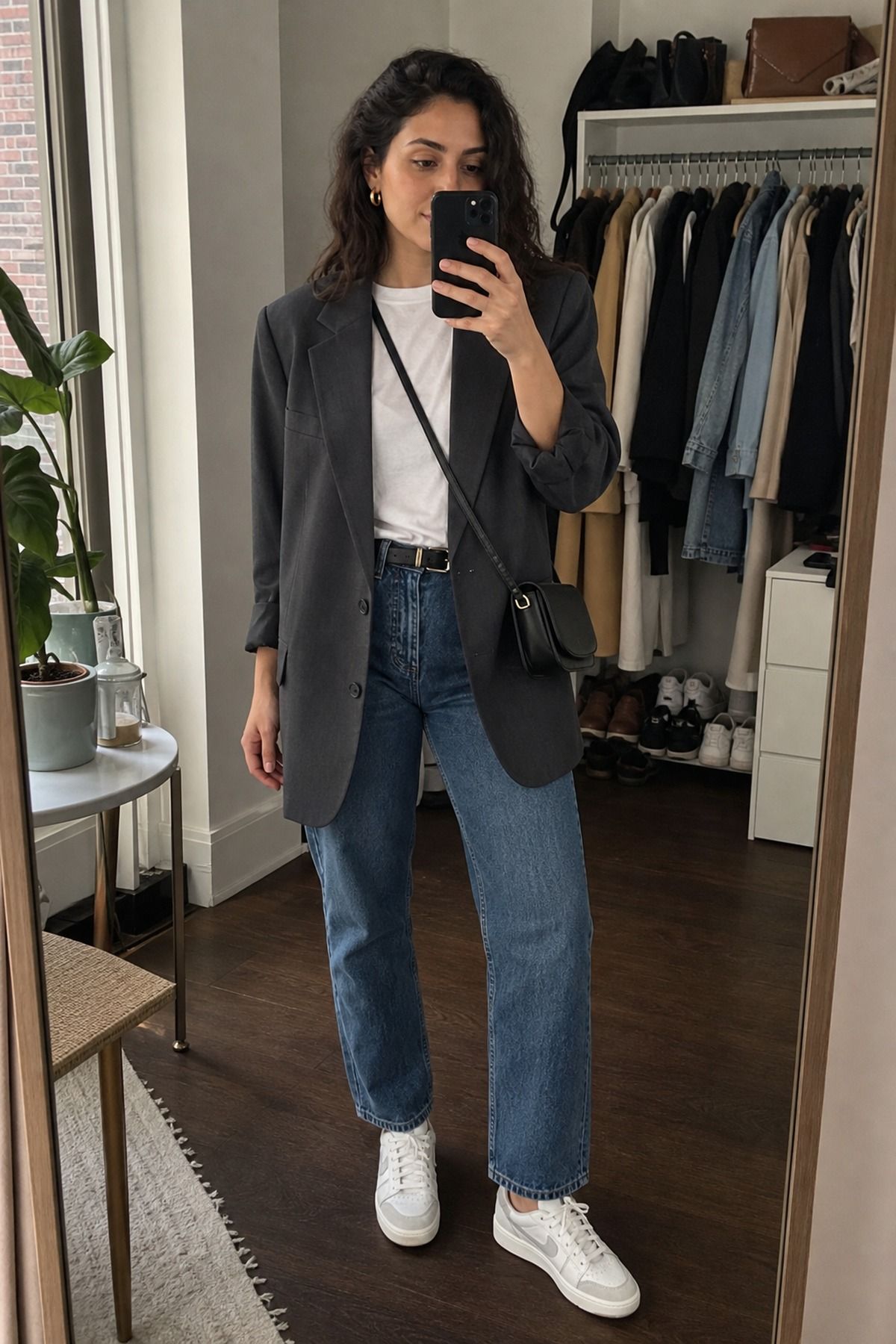 Woman wearing an oversized blazer with straight jeans and sneakers, a NYC casual outfit