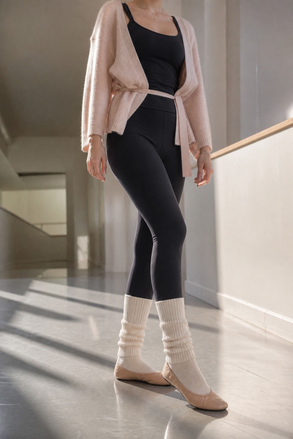 Woman wearing leg warmers with a simple black set, a Pilates princess outfit