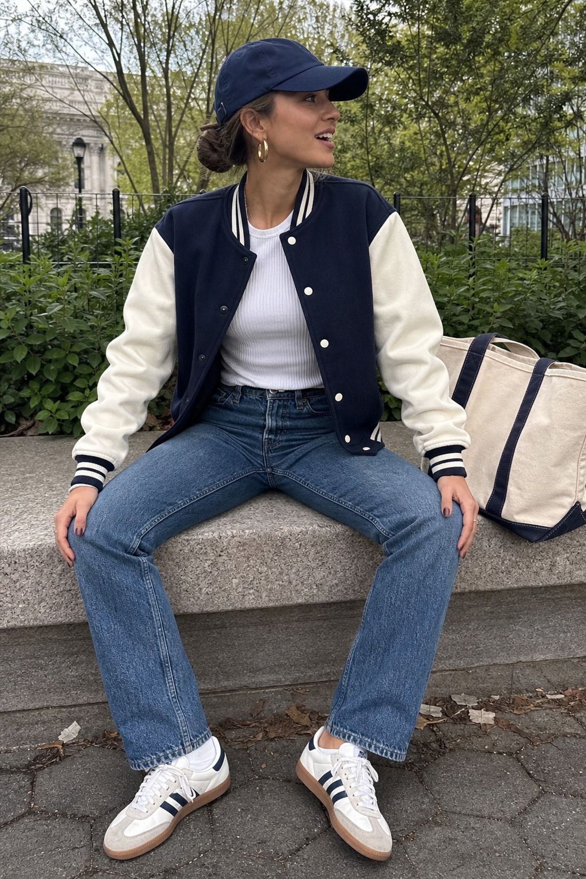 Woman wearing a varsity jacket with a ribbed tee and jeans, a preppy casual outfit