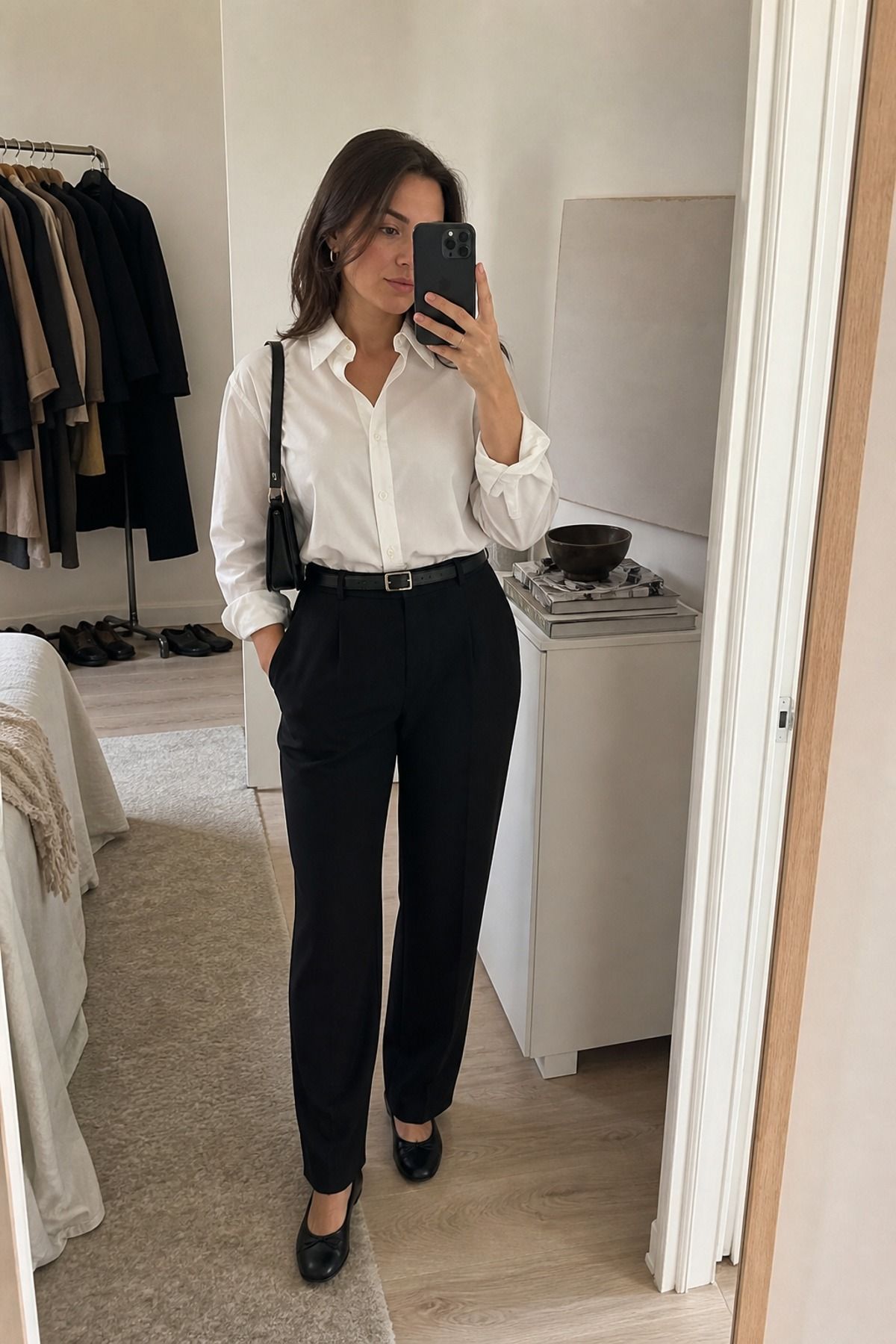 Woman wearing a white button down with black trousers, a Scandinavian style outfit