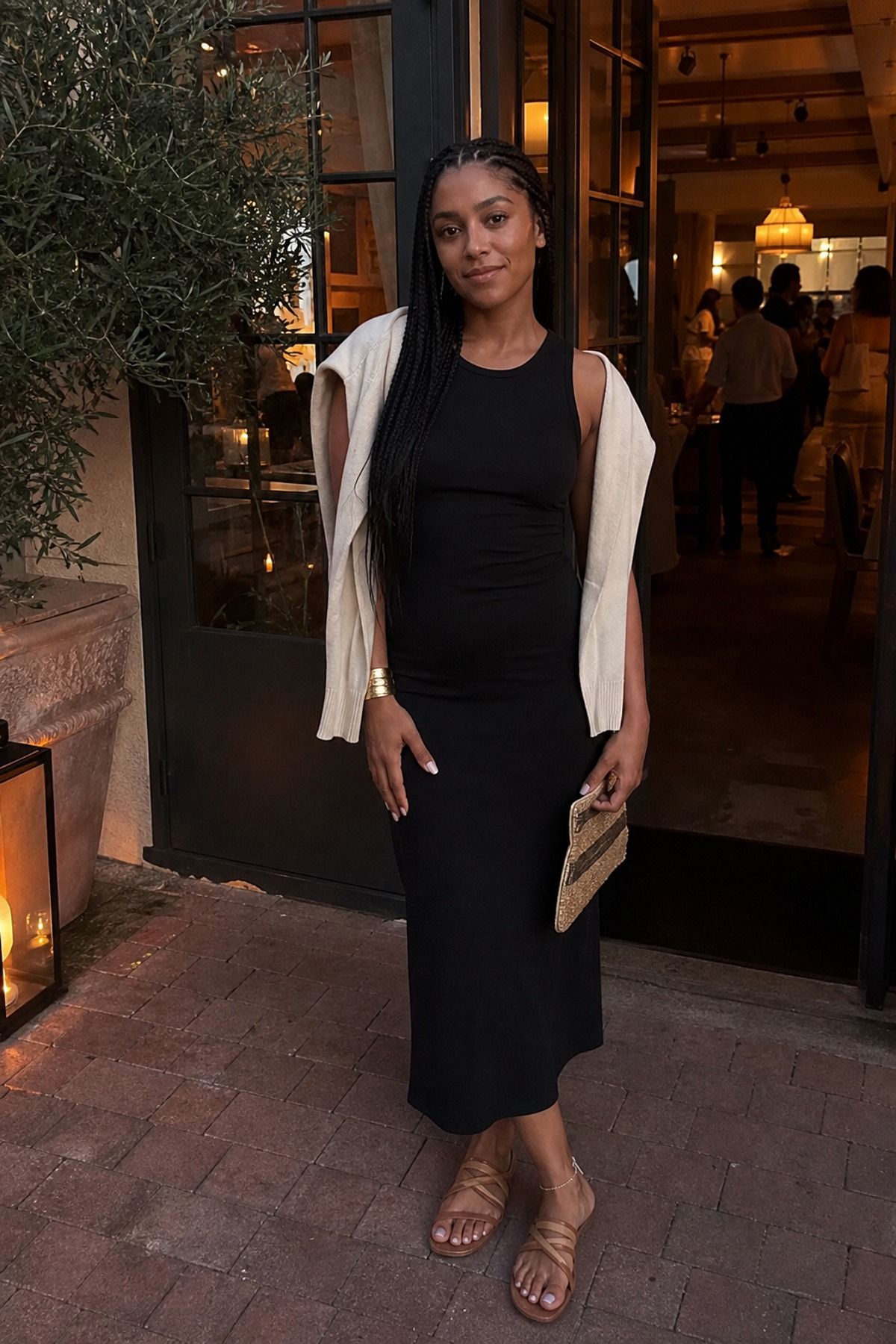 Woman wearing a black midi dress with flat sandals, a Scandinavian style outfit