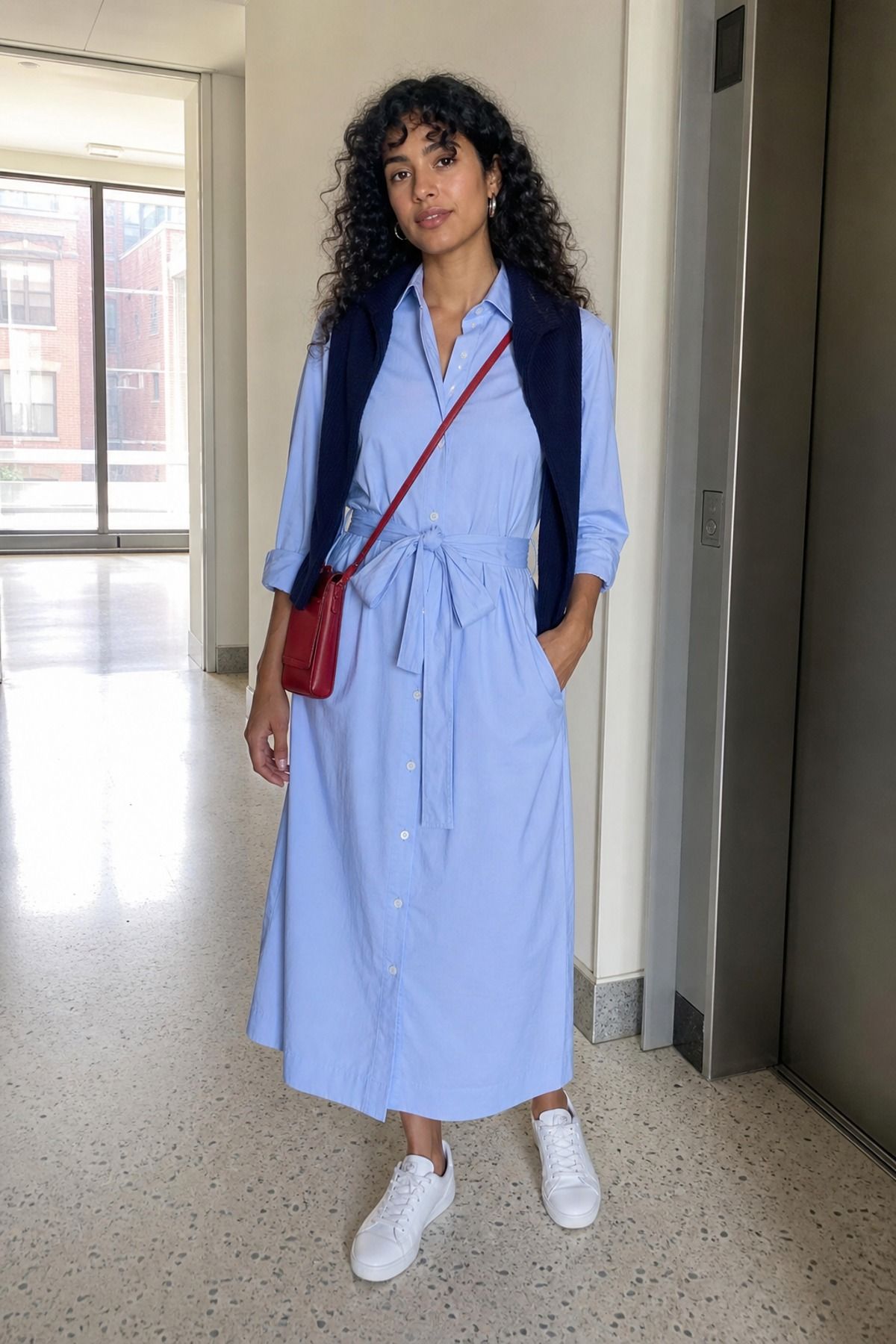 Woman wearing a belted shirt dress with sneakers, a Scandinavian style outfit