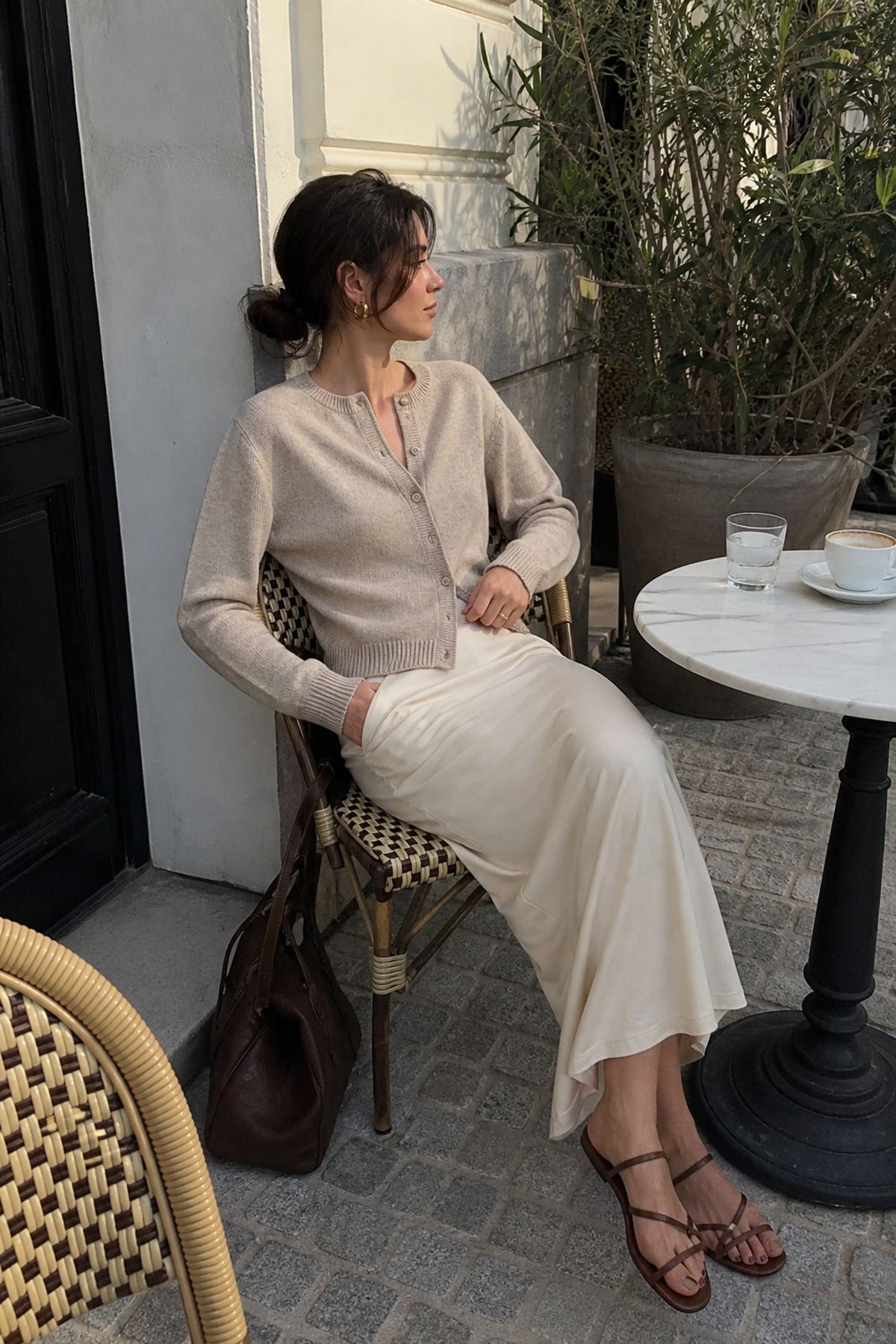 Woman wearing a fine knit cardigan with a column skirt, a 90s minimalist outfit