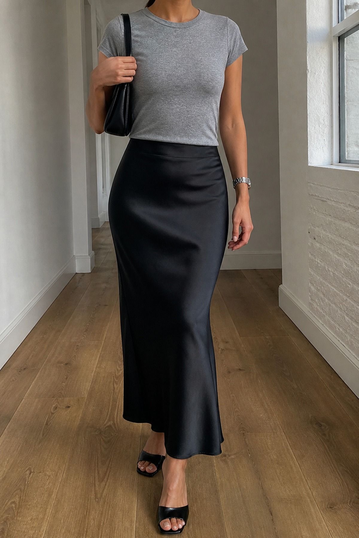 Woman wearing a gray tee with a black slip skirt, a 90s minimalist outfit