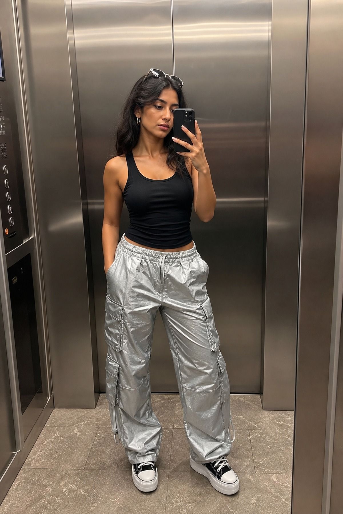 Woman wearing silver cargo pants with a black tank, an aliencore outfit