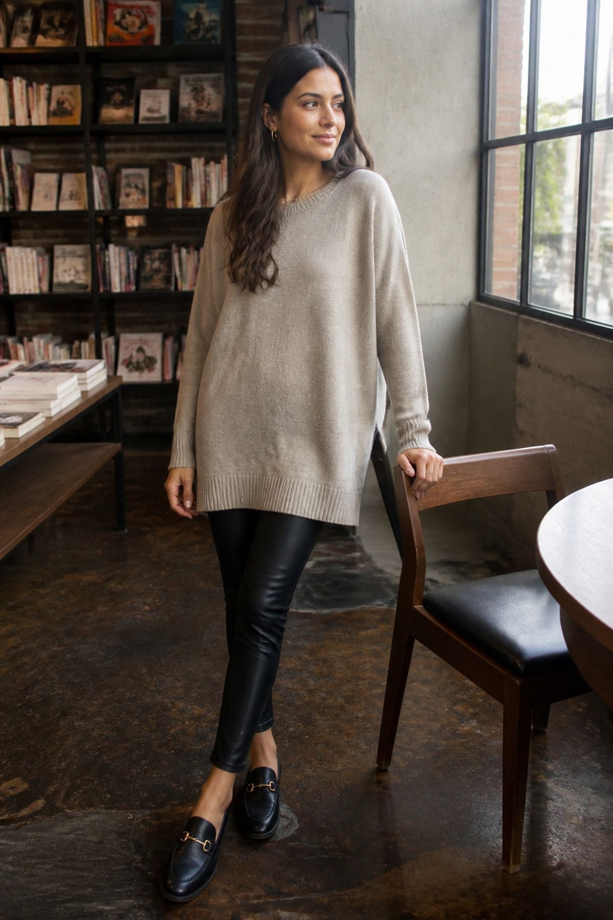 Woman wearing a tunic sweater with faux leather leggings
