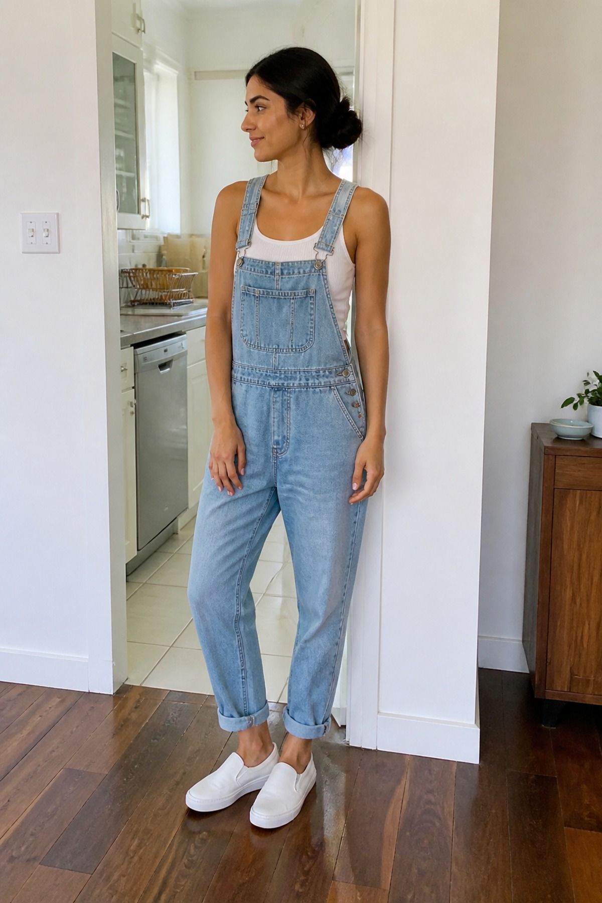 Woman wearing overalls with a tank and slip-on sneakers, a casual mom outfit