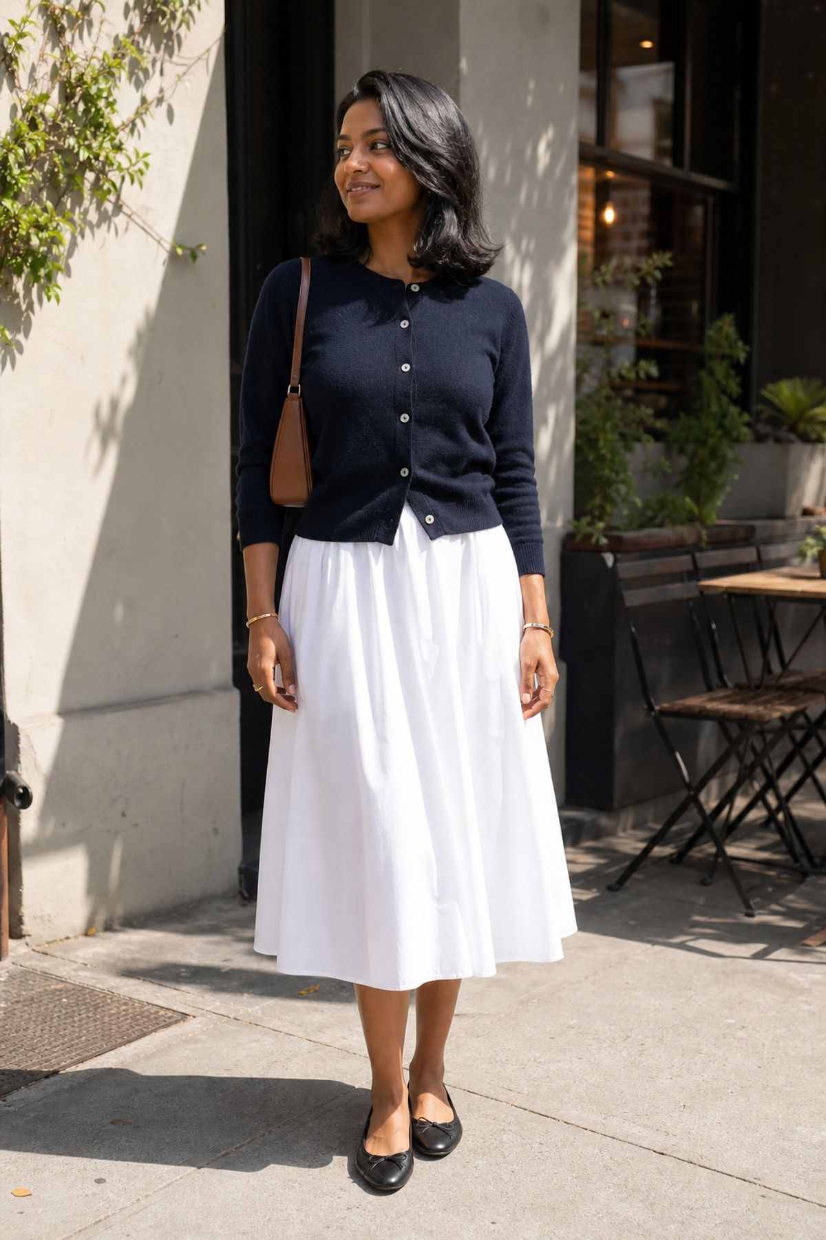 Woman wearing a poplin skirt with a buttoned cardigan