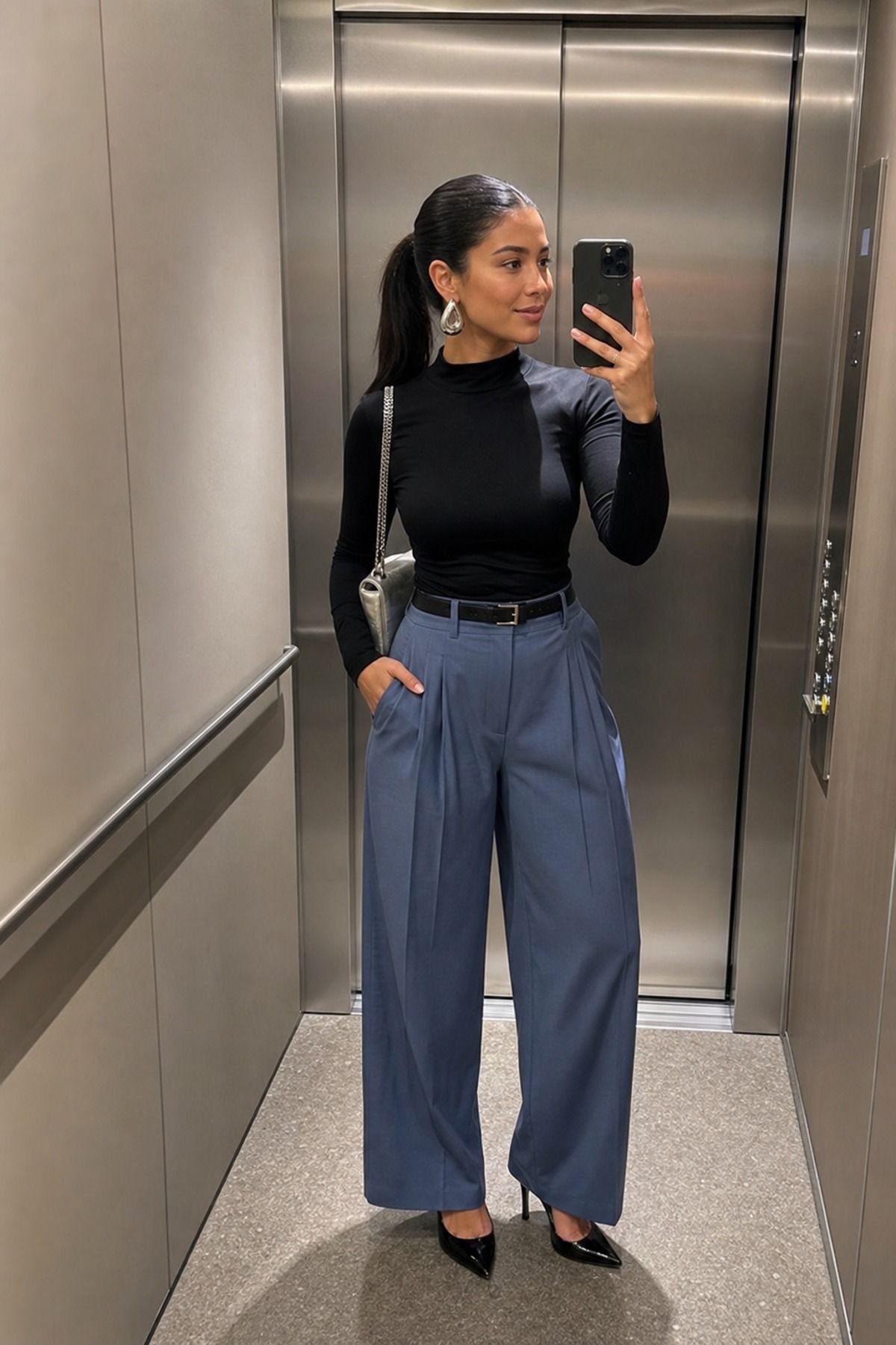 Woman wearing pleated trousers with a statement earring, a glamoratti outfit