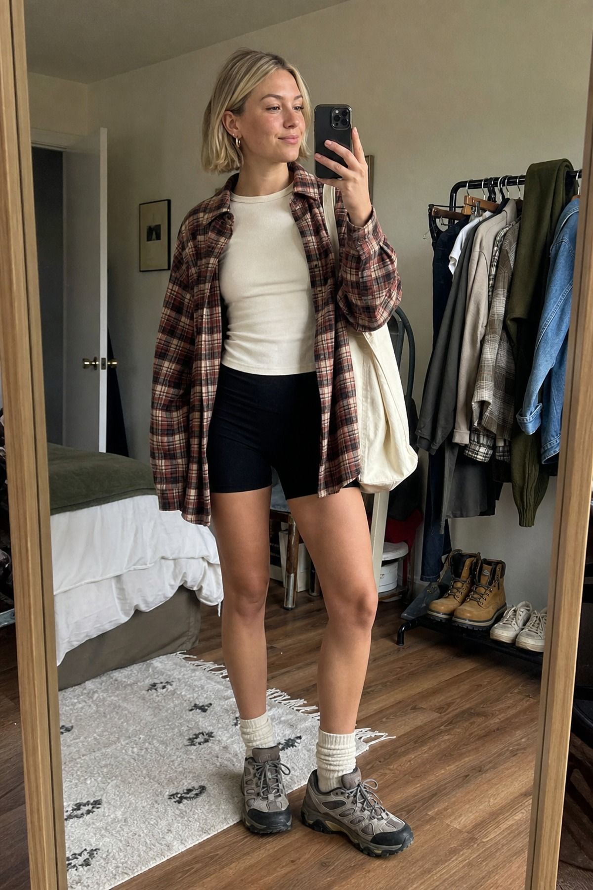 Woman wearing a flannel shirt with bike shorts and trail sneakers, a granola girl outfit