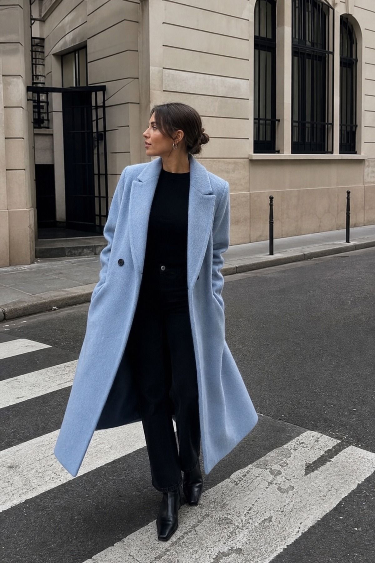 Woman wearing an icy blue coat with an all black base
