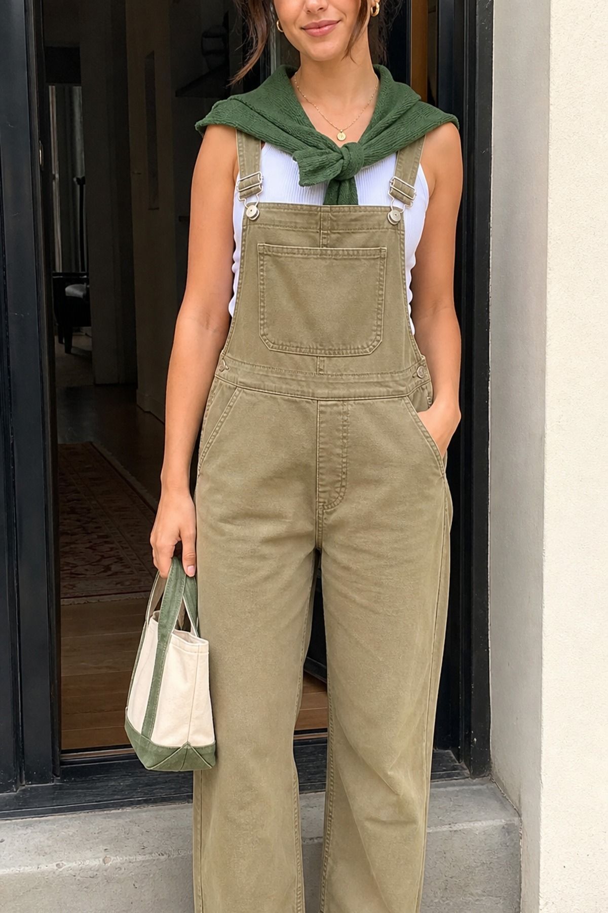 Woman wearing khaki overalls with a ribbed tank