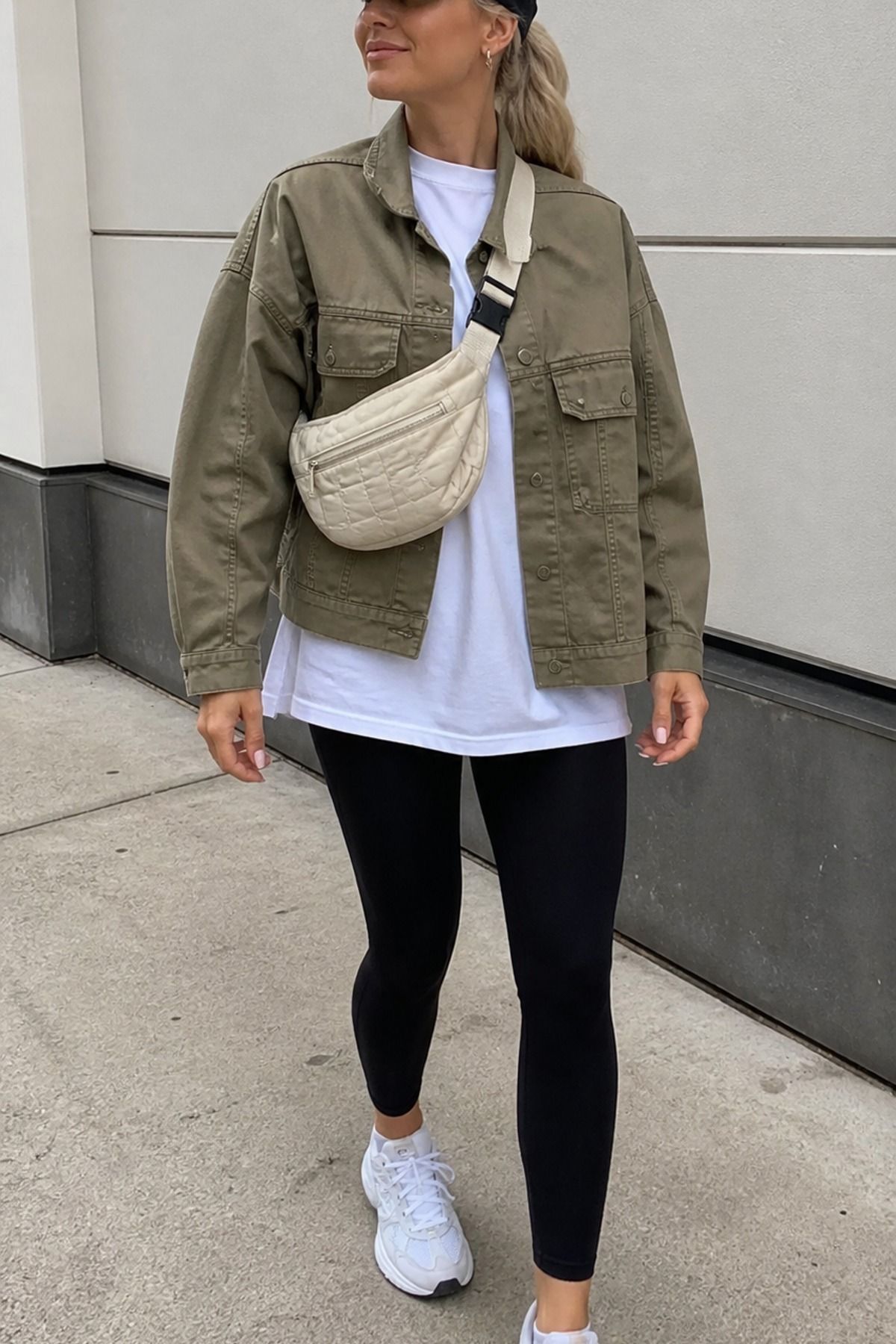 Woman wearing a khaki jacket with black leggings