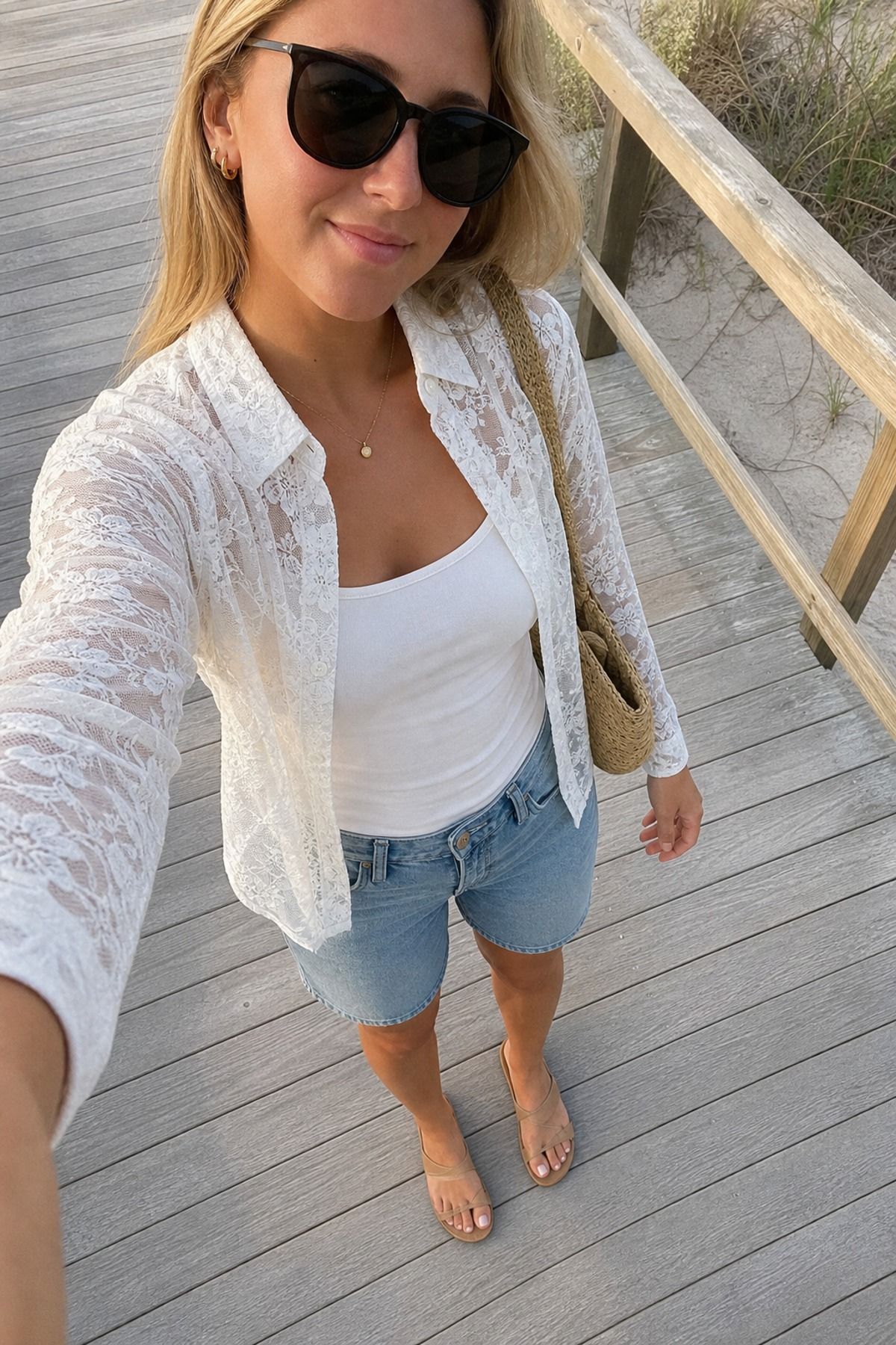 Woman wearing a sheer lace shirt over a tank and denim shorts