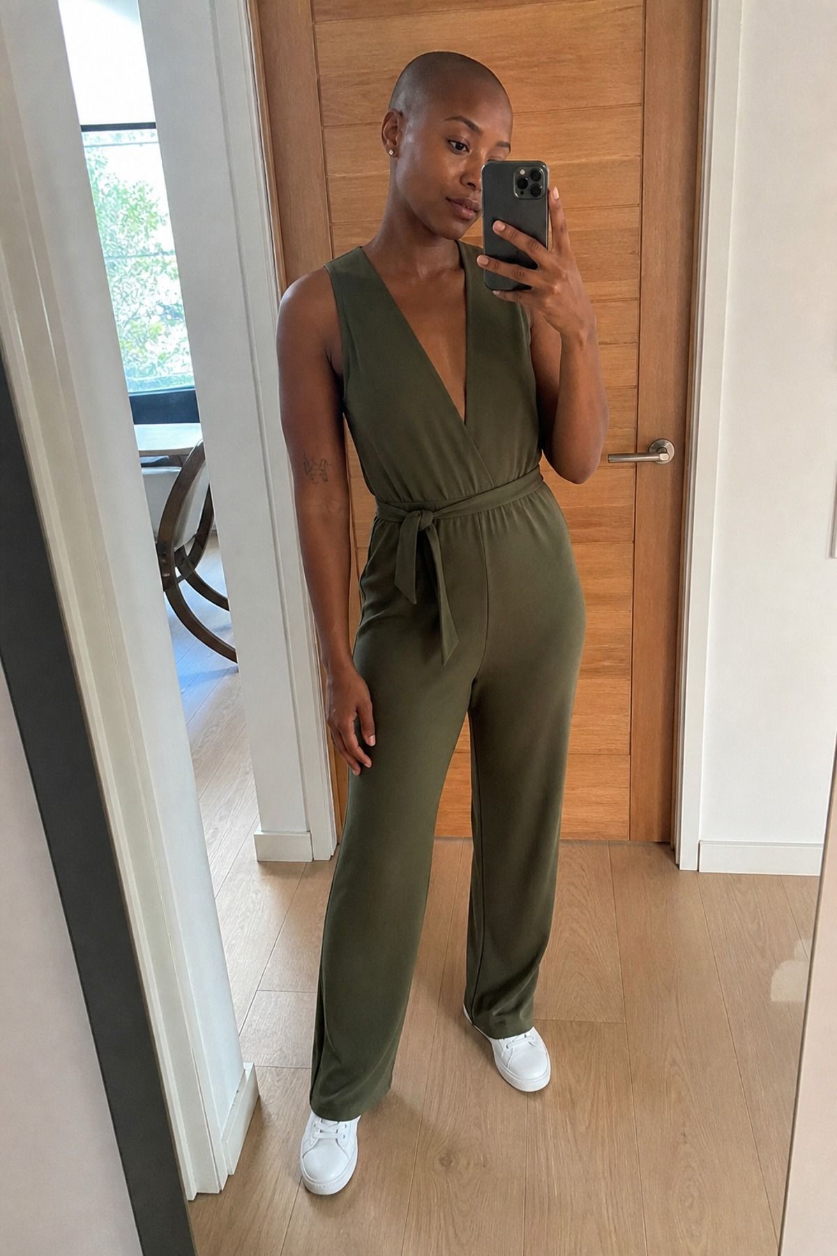 Woman wearing a v-neck jumpsuit with low sneakers