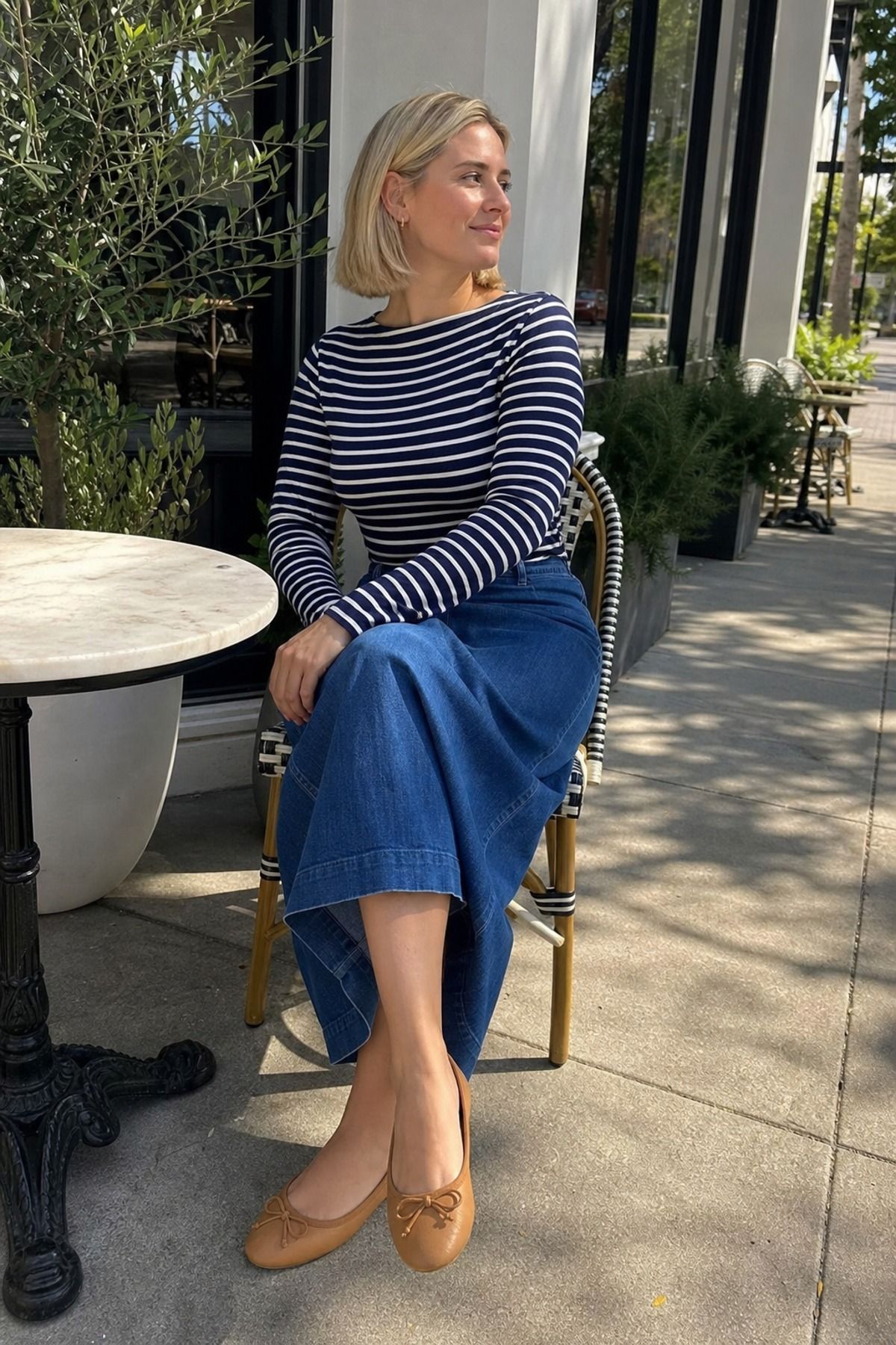 Woman wearing a striped boatneck top with an a-line denim skirt