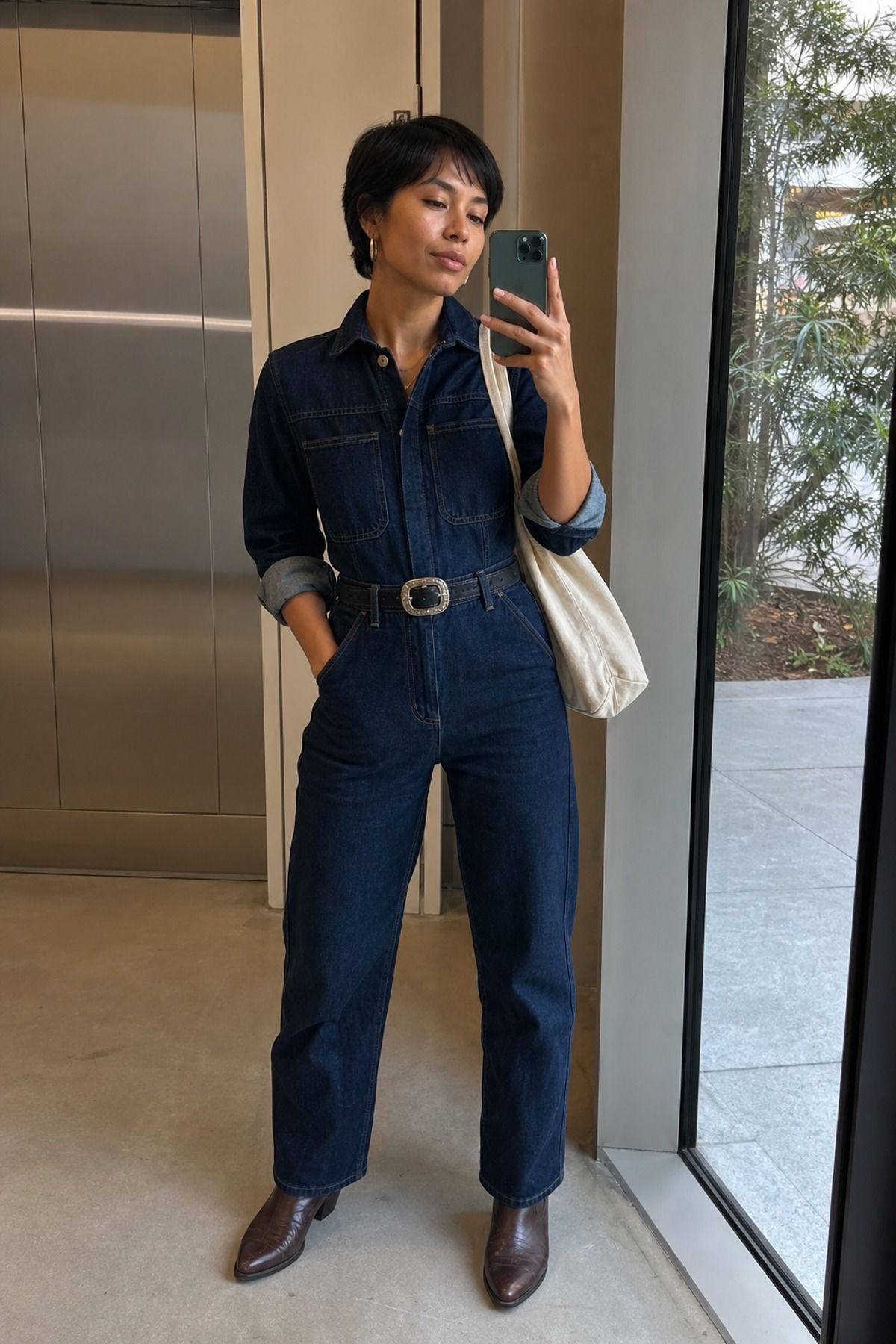 Woman wearing a dark denim jumpsuit with Western boots, a Western casual outfit