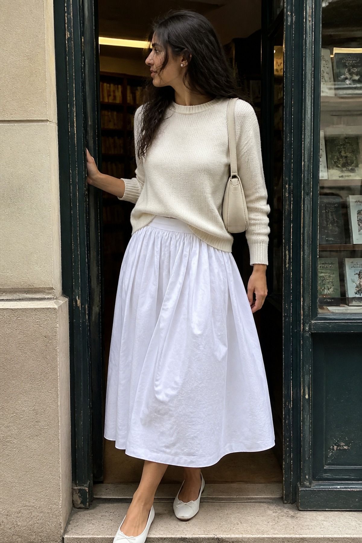 Woman wearing a white poplin skirt with an ivory sweater, an all white outfit