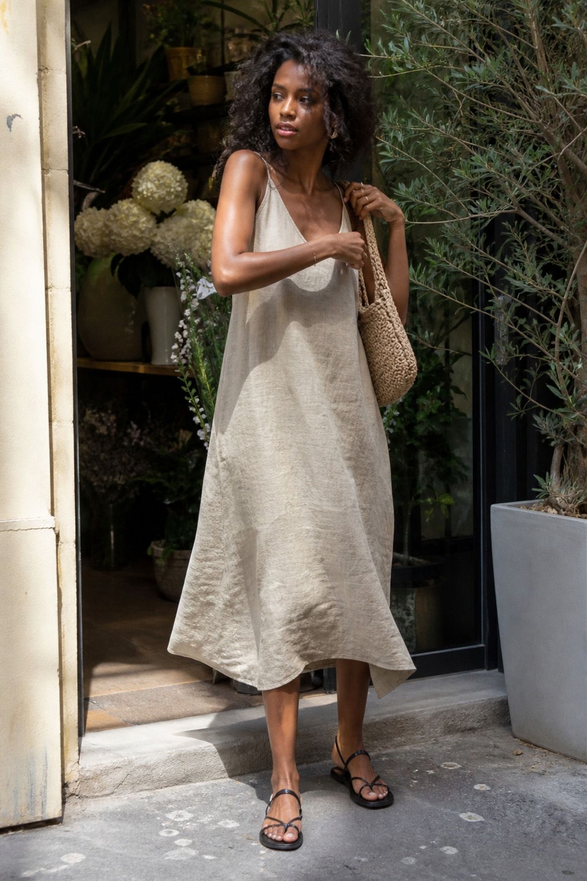 Woman wearing a beige linen dress with black sandals