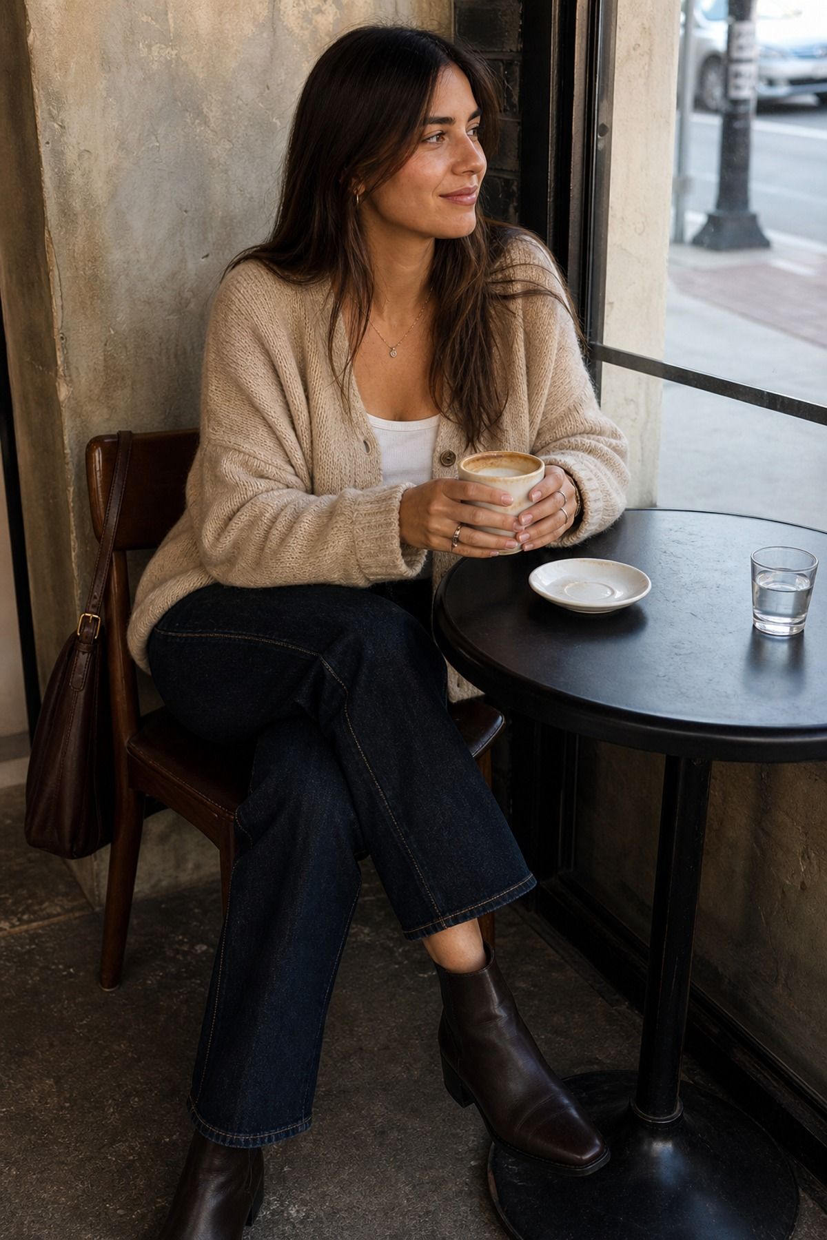 Woman wearing a beige cardigan with dark denim