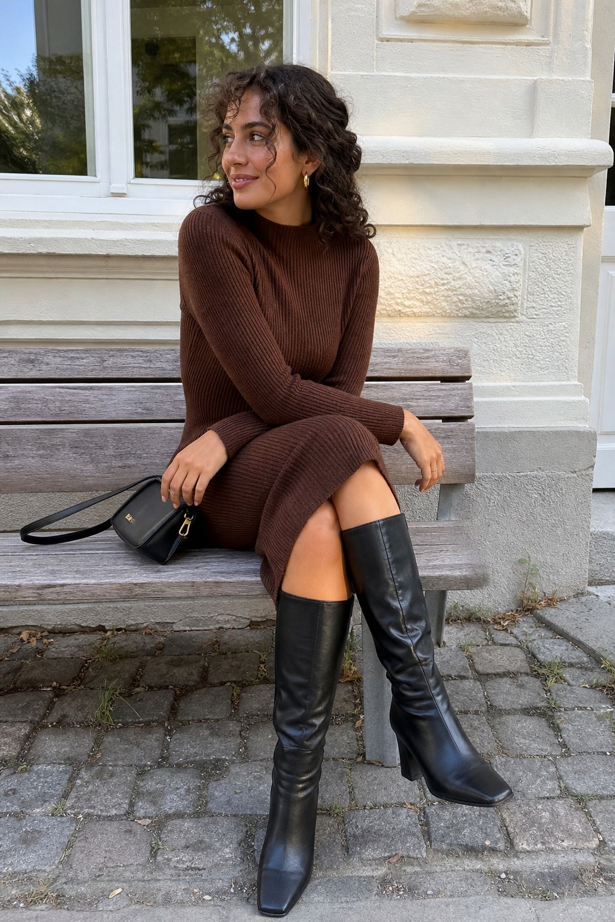 Woman wearing a brown sweater dress with black boots, a black and brown outfit