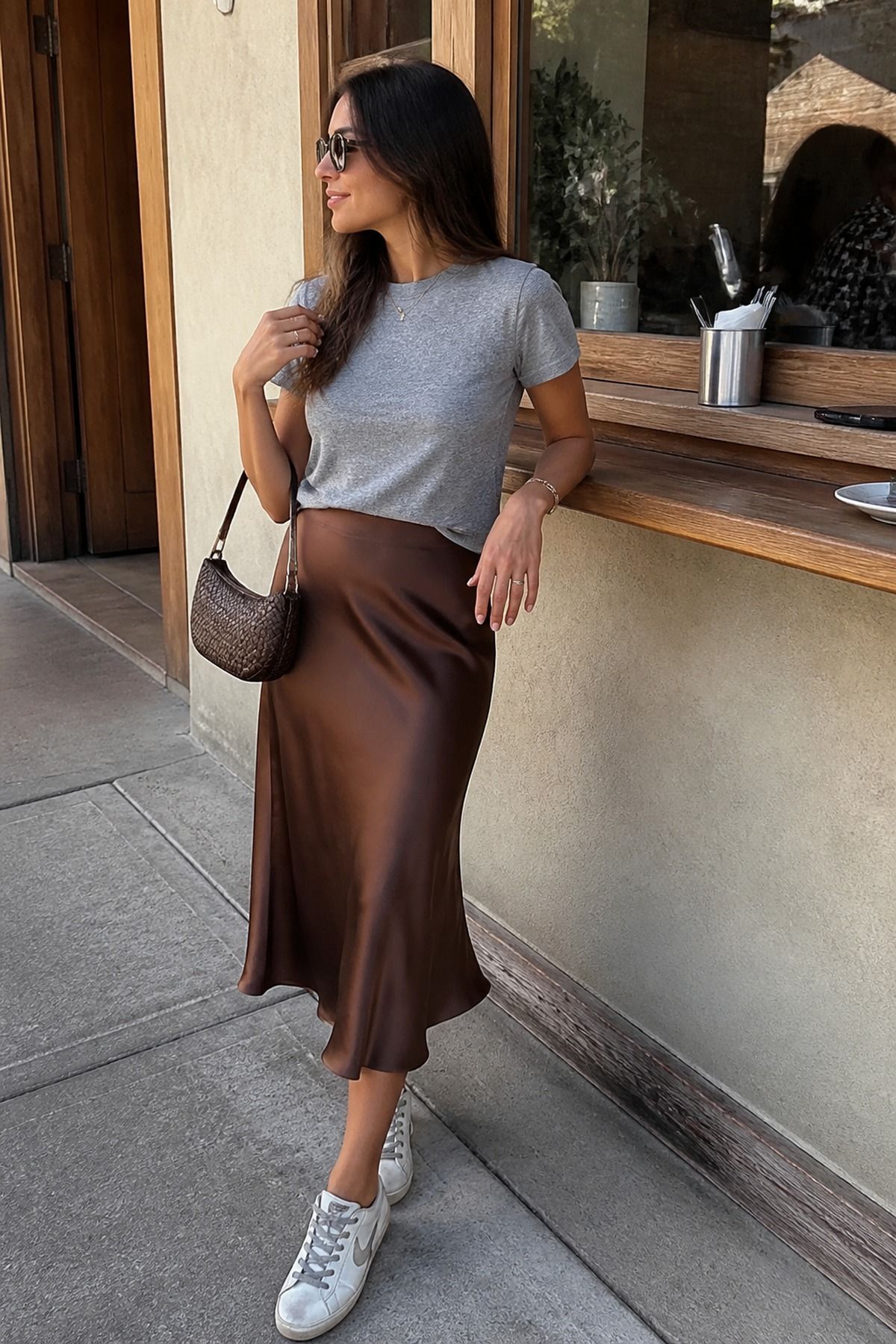 Woman wearing a brown satin skirt with a gray tee