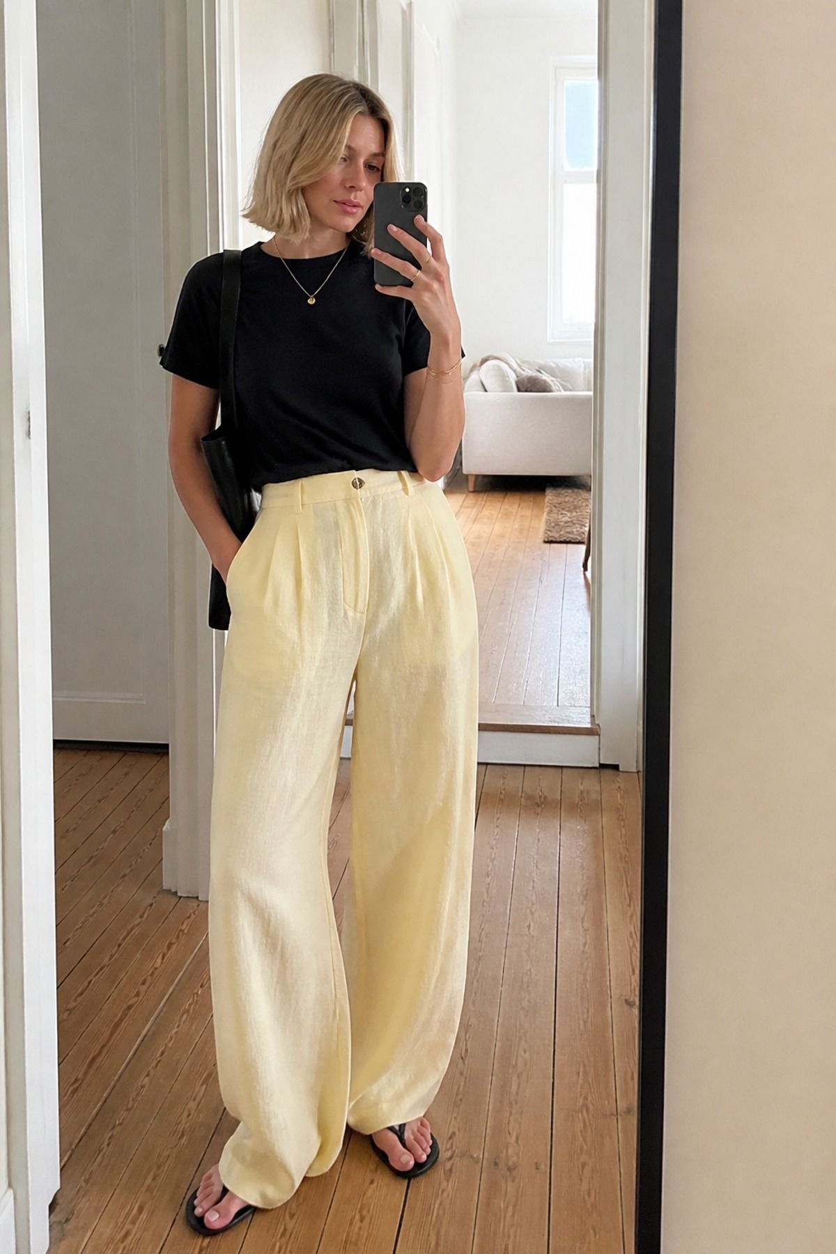 Woman wearing pale yellow linen pants with a black tee, a butter yellow outfit