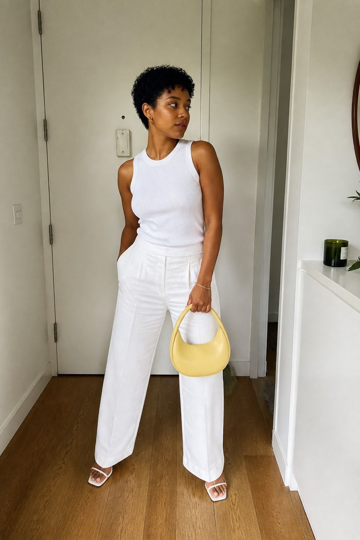 Woman wearing a butter yellow bag with an all-white outfit