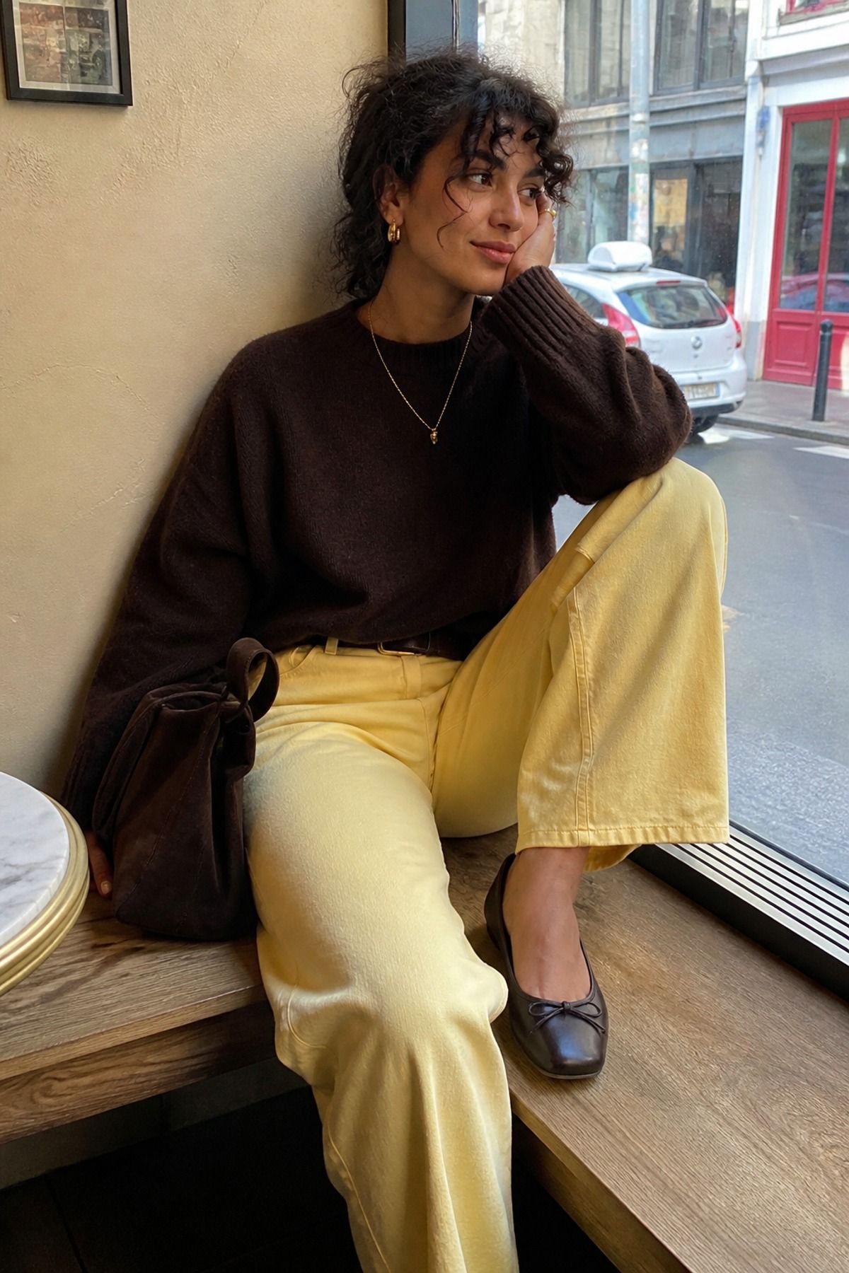 Woman wearing a chocolate brown sweater with yellow pants, a butter yellow outfit