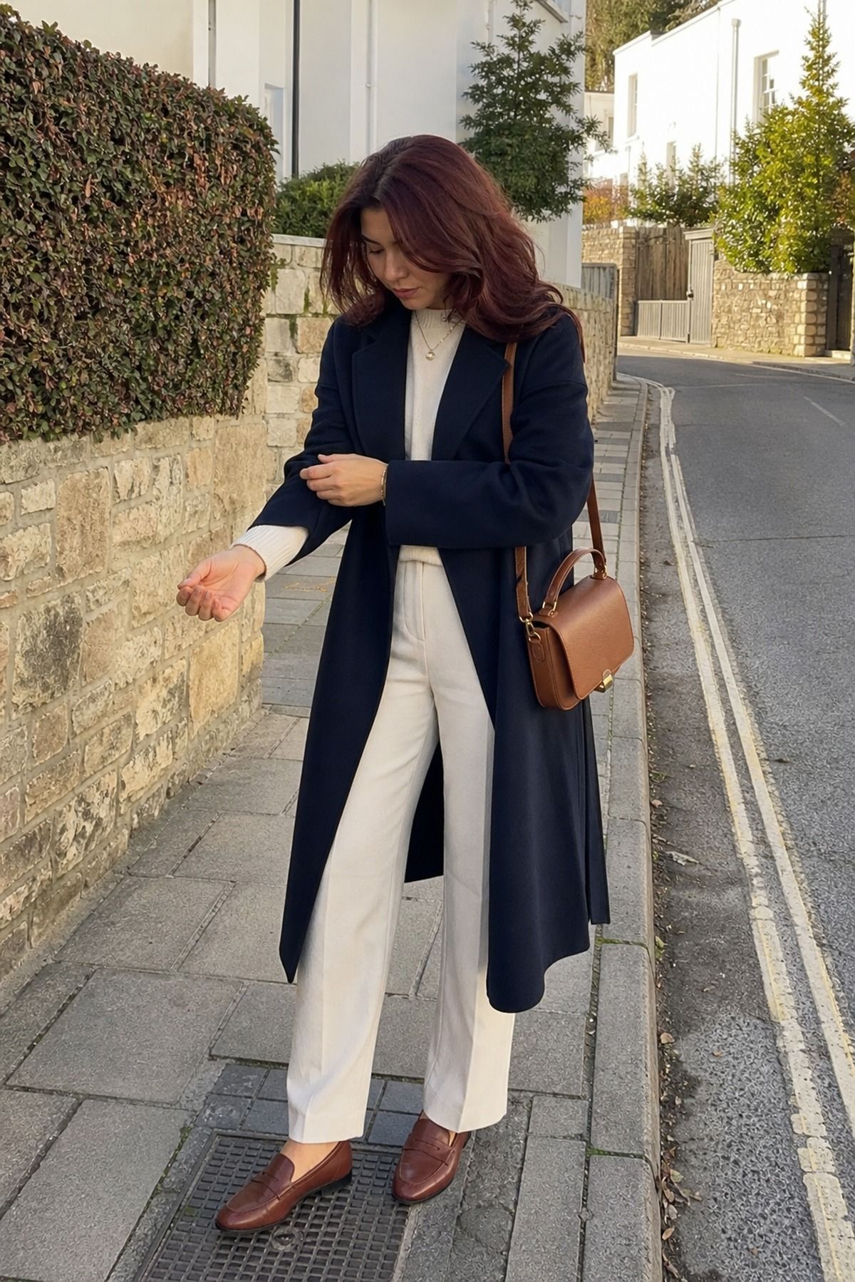 Woman wearing a navy coat over a cream base